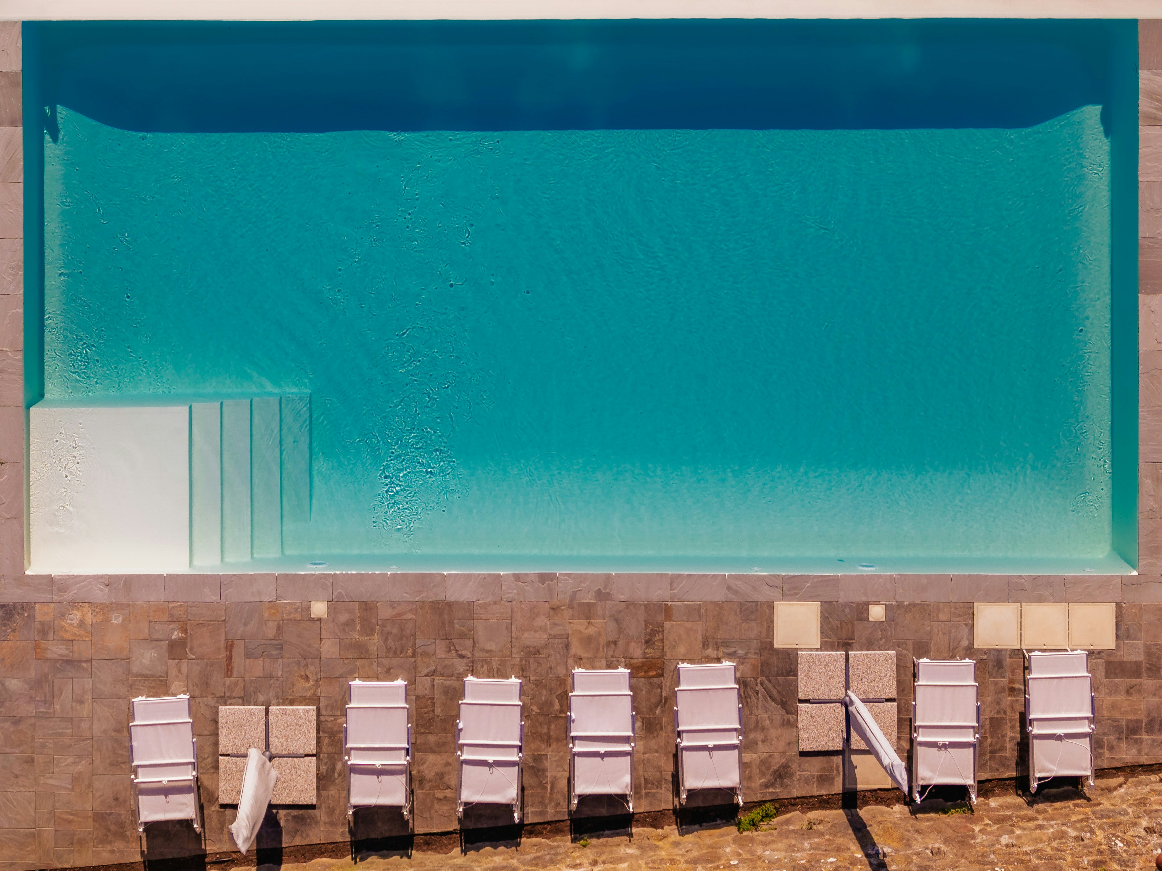 Aerial view of a swimming pool with lounge chairs
