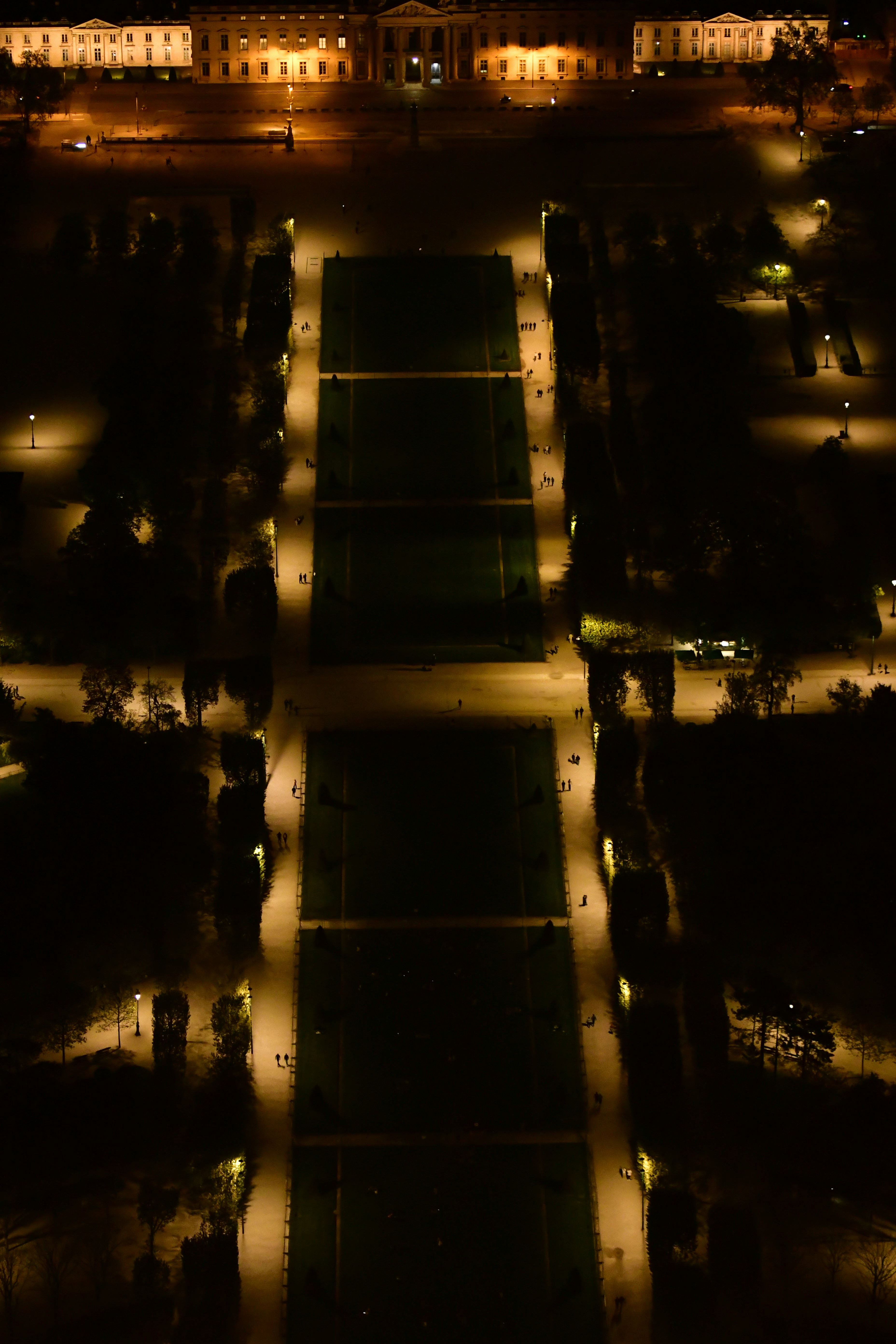 Aerial view of a park at night with illuminated buildings.