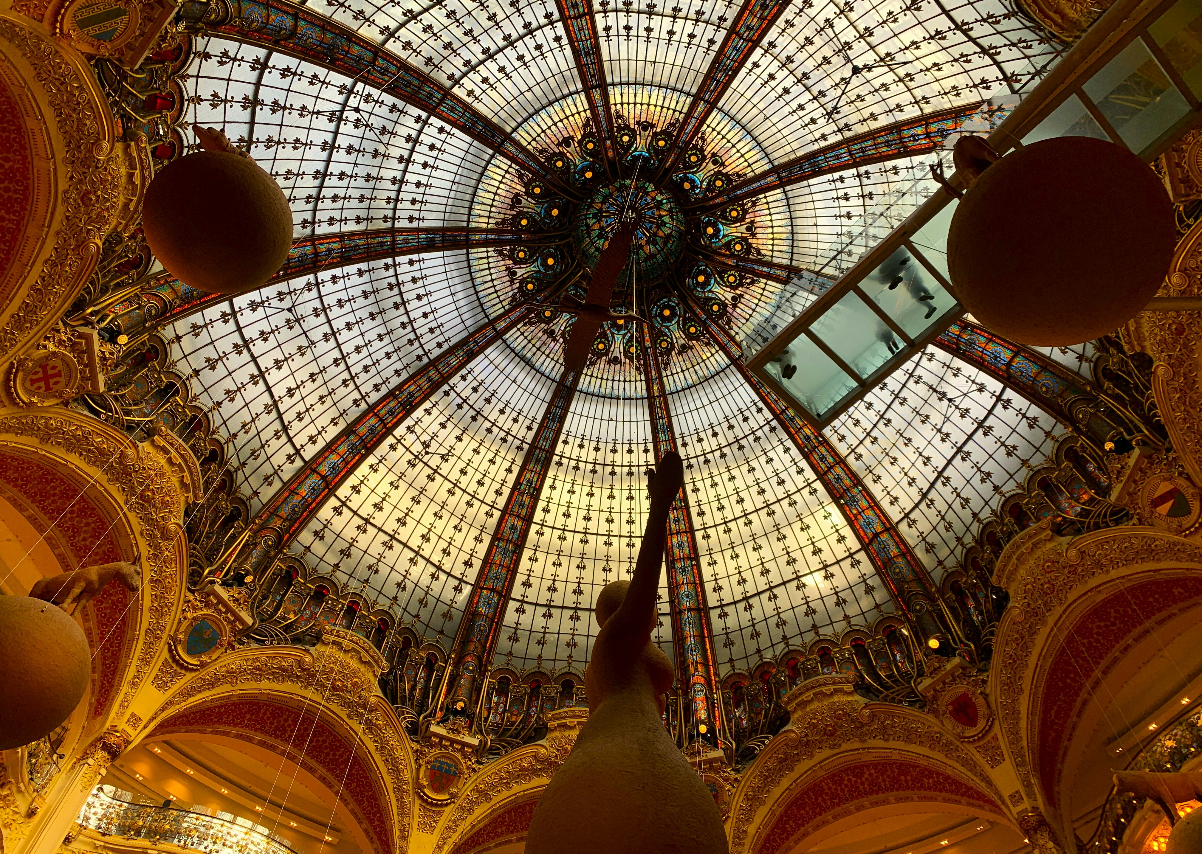 Ornate glass dome with decorative elements and hanging spheres