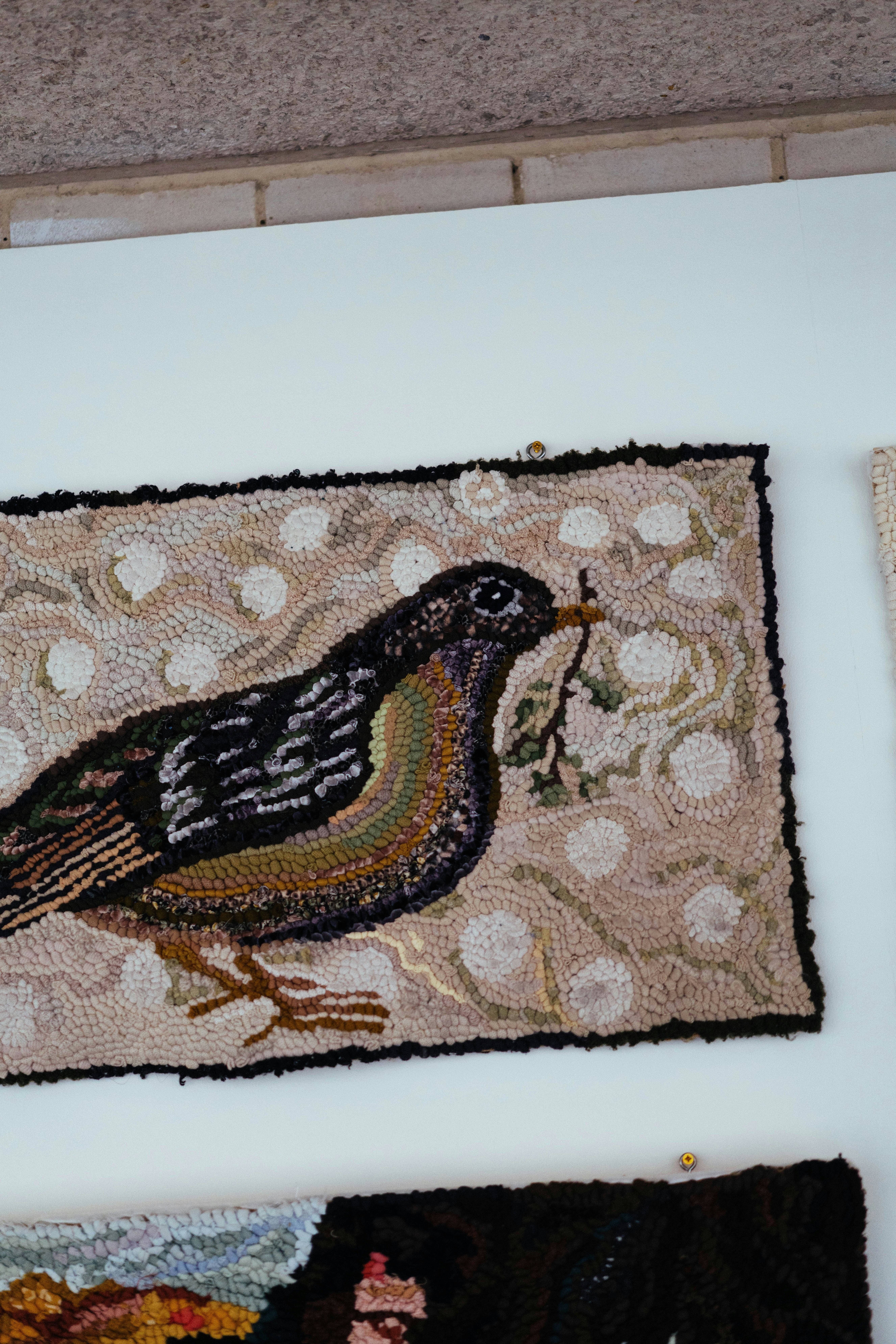 フック状のラグには、小枝を持つコマドリが描かれています。