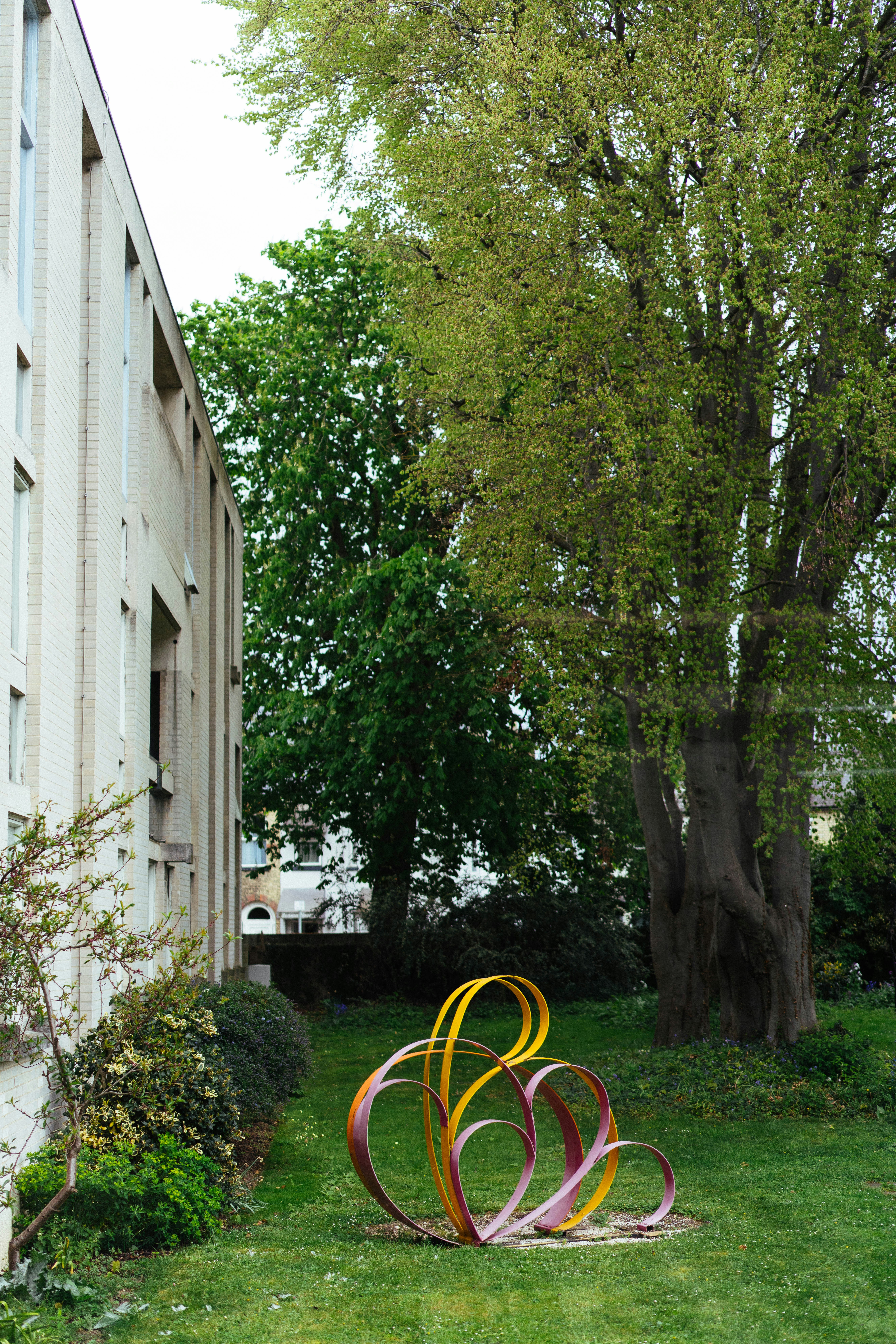 建物の近くの芝生に描かれたカラフルな抽象彫刻。