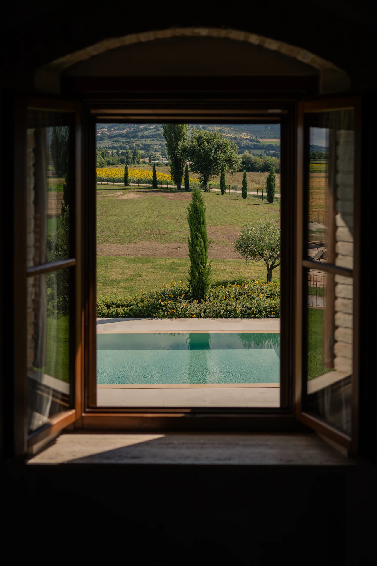 A swimming pool seen through an open casement window