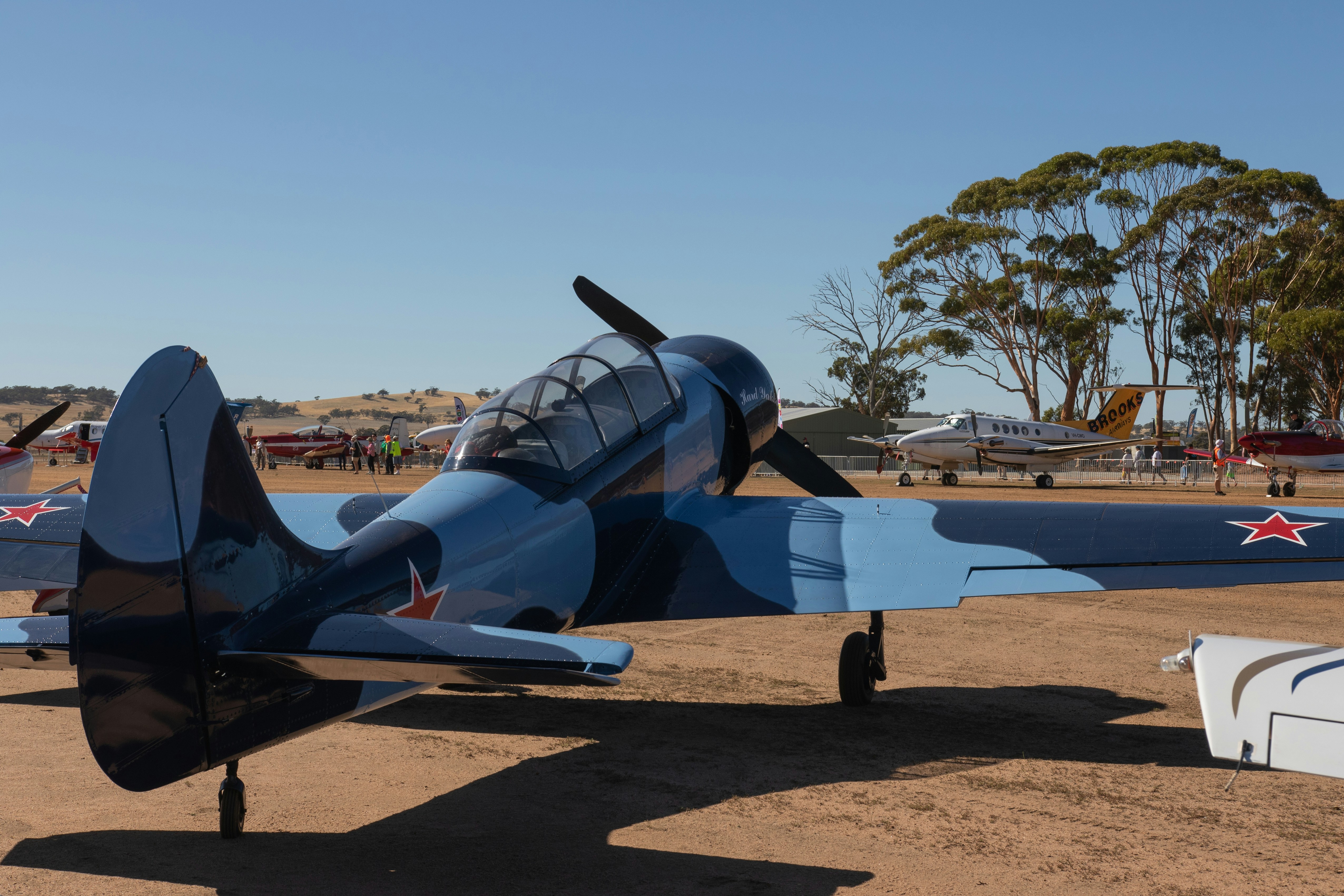 Un avion camouflage bleu et noir par une journée ensoleillée.