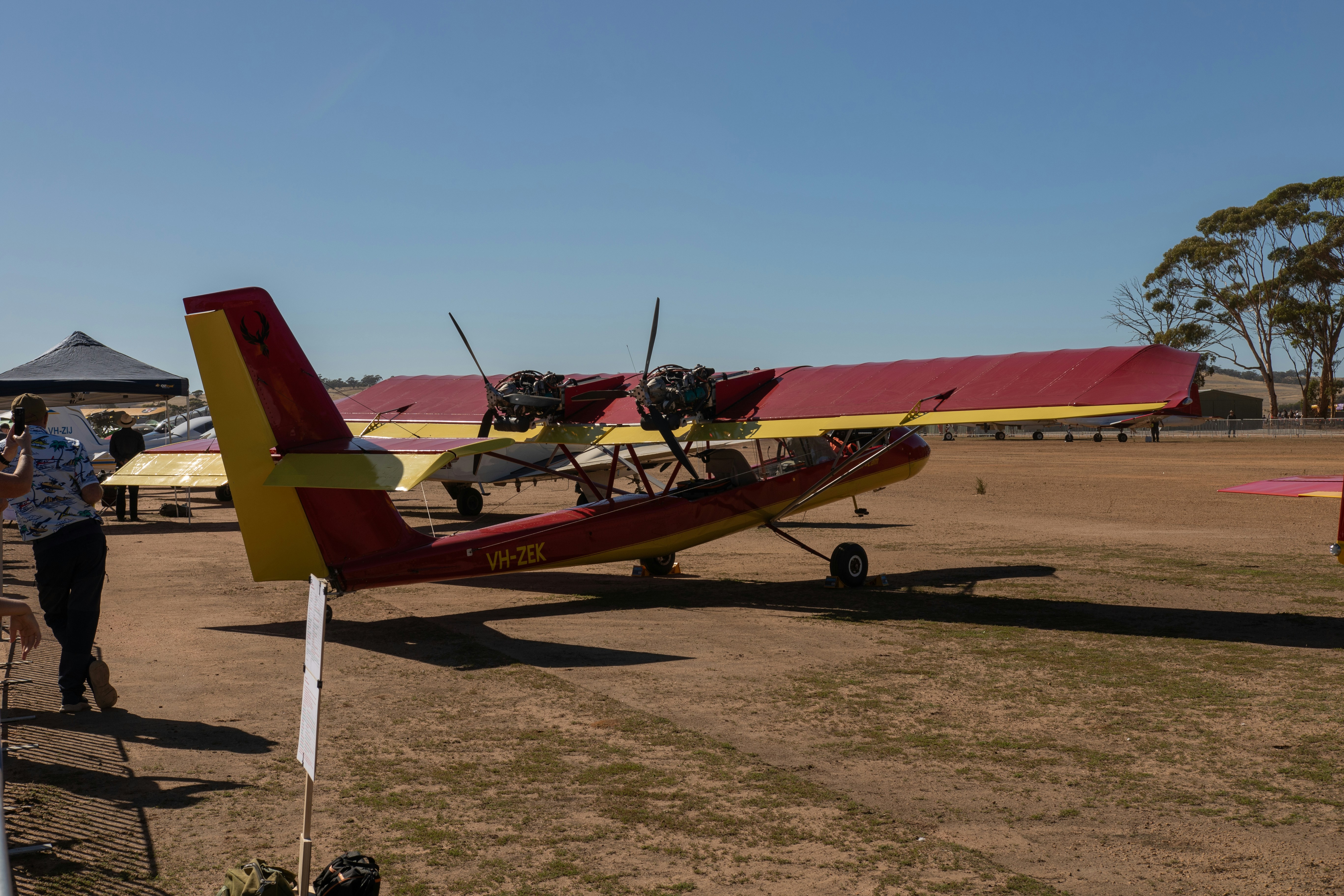 Un hydravion bimoteur rouge et jaune au sol