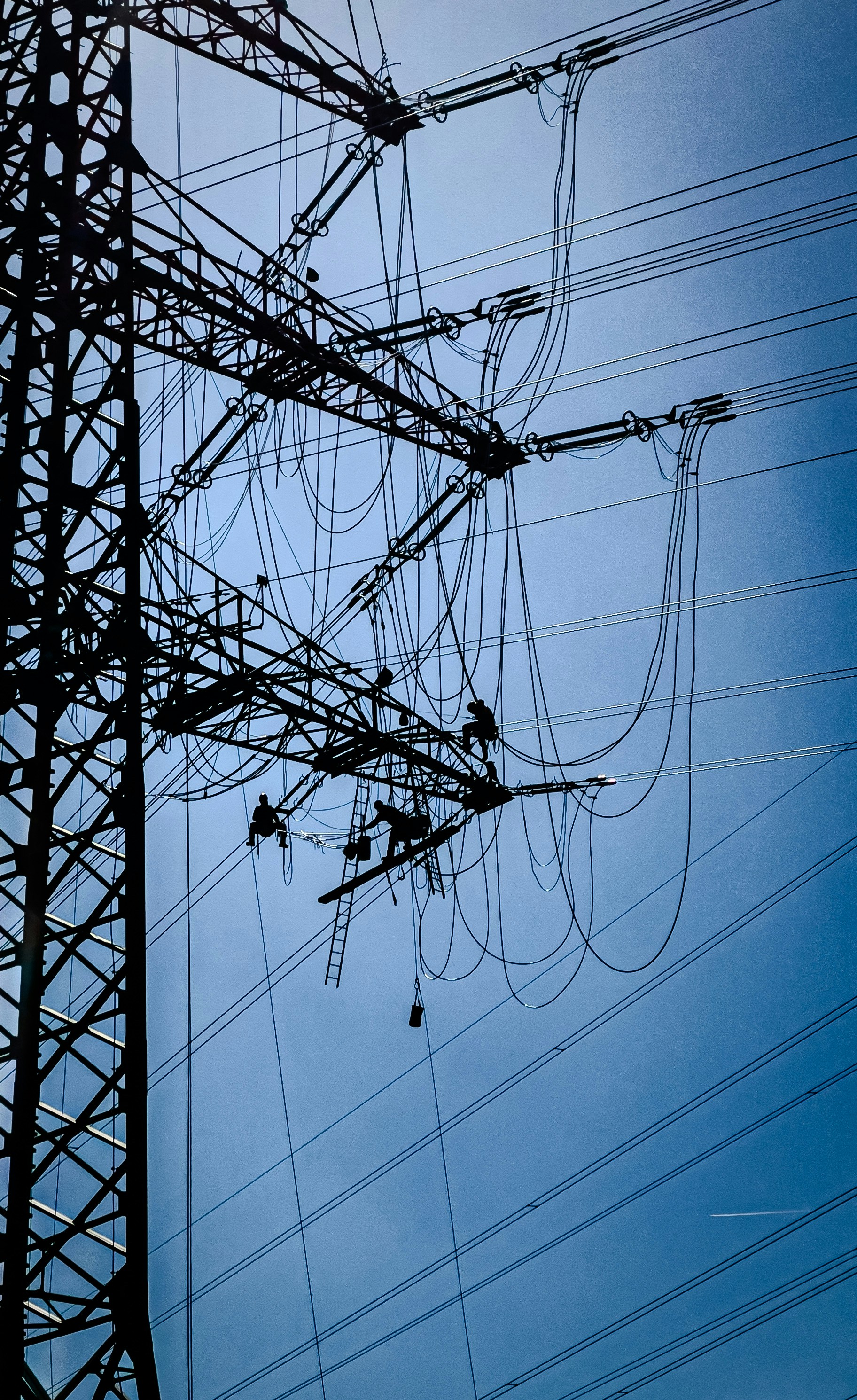 作業員は送電塔の送電線を維持管理しています。