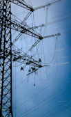 Workers maintain power lines on a transmission tower.