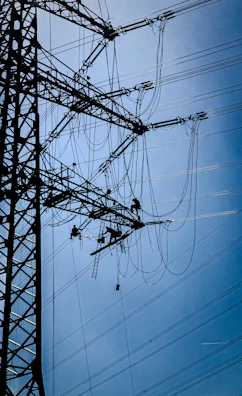 Workers maintain power lines on a transmission tower.