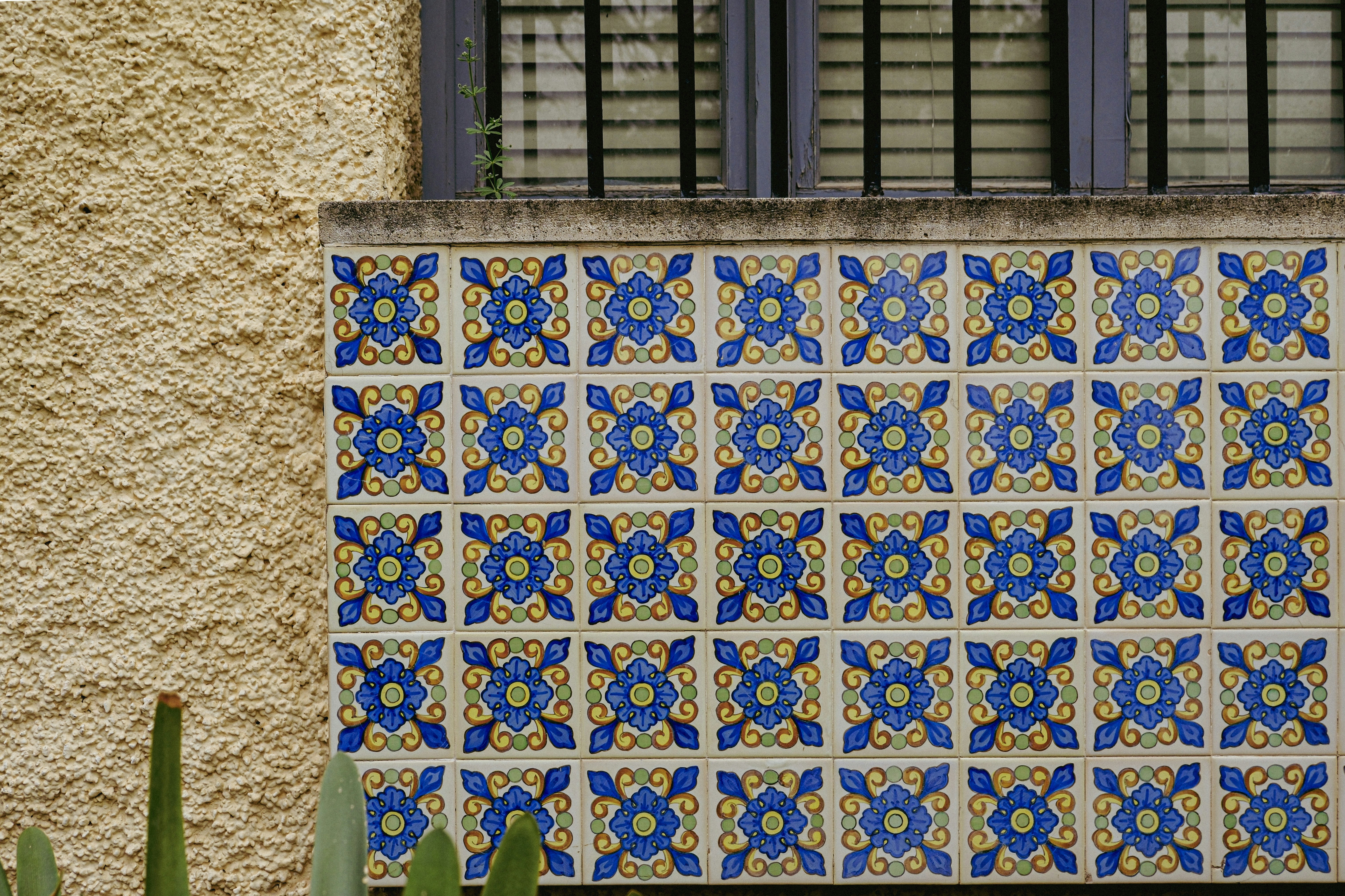 Decorative blue and yellow tiles on a textured wall.