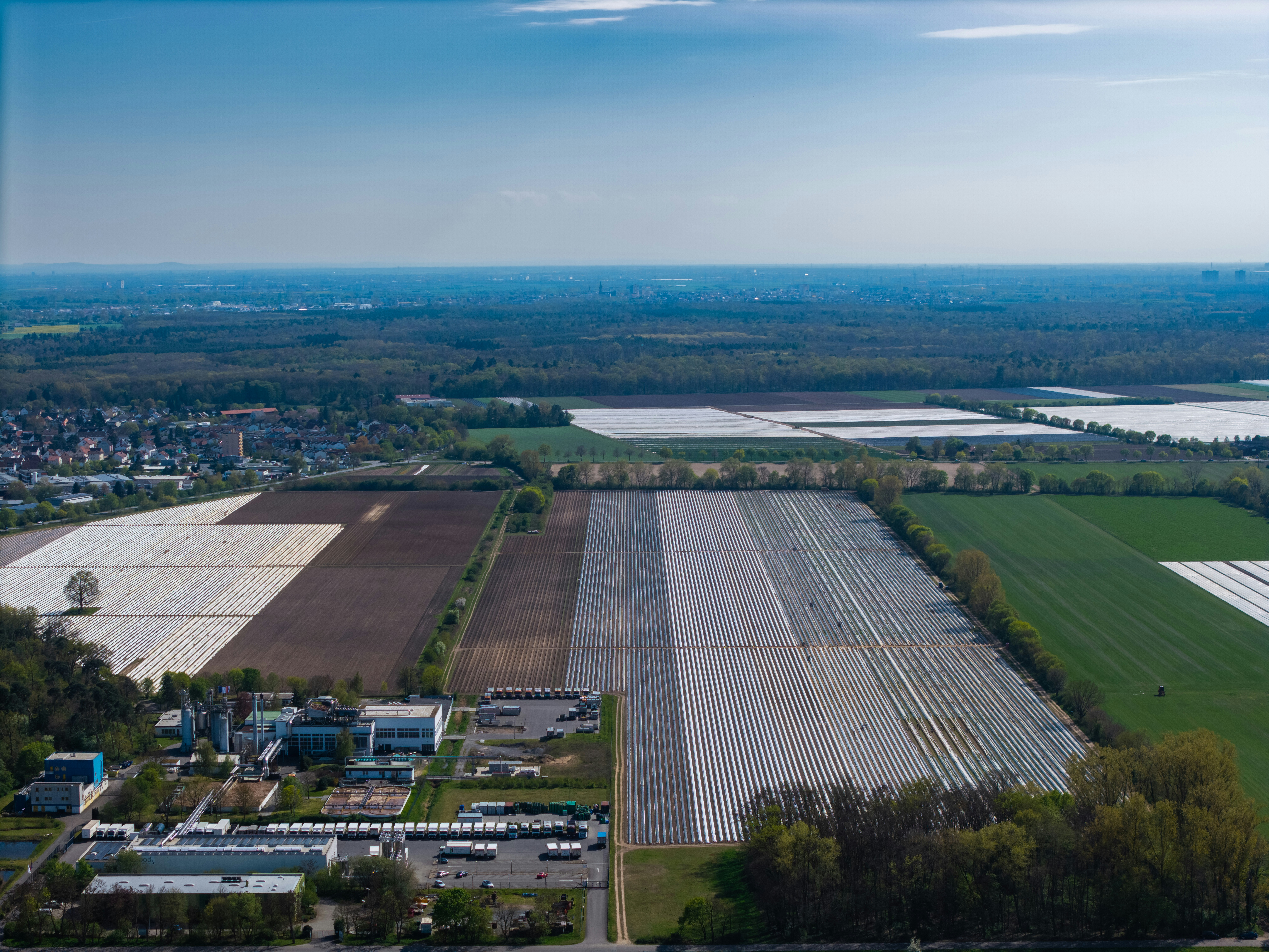 Aerial view of agricultural fields and industrial buildings.