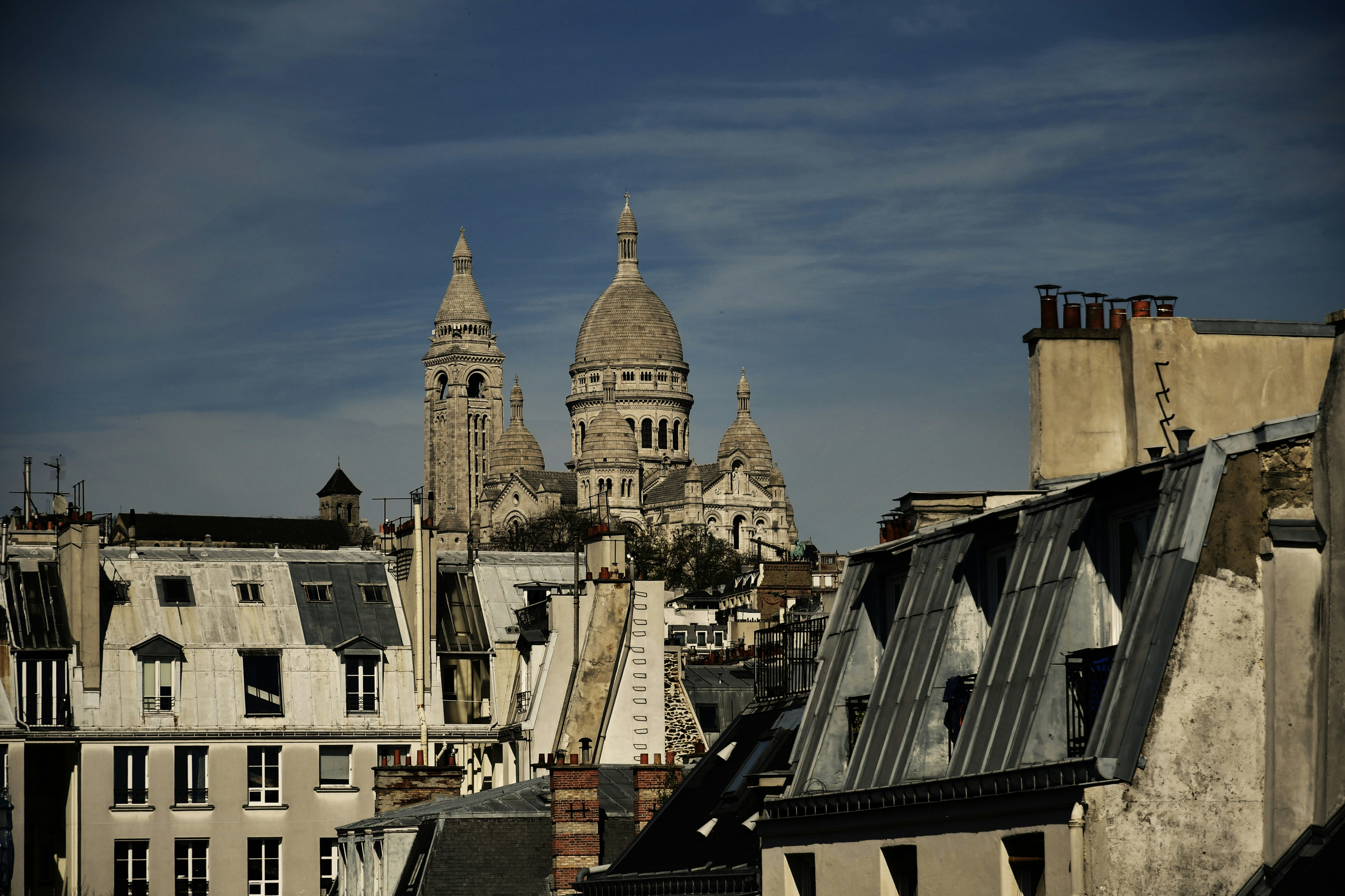 Rooftops and sacré-cœur basilica under a blue sky