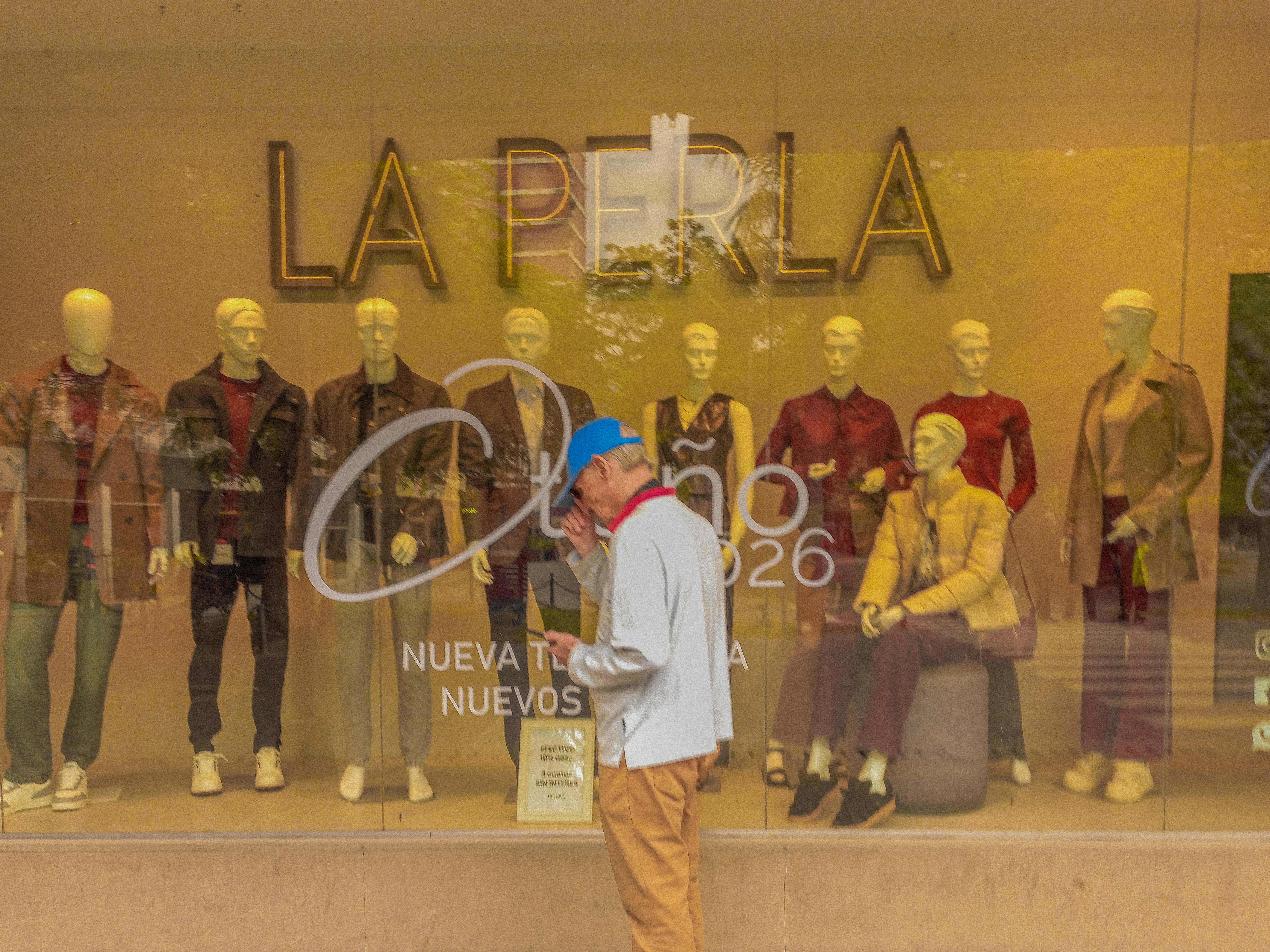 Man looking at mannequins in a window