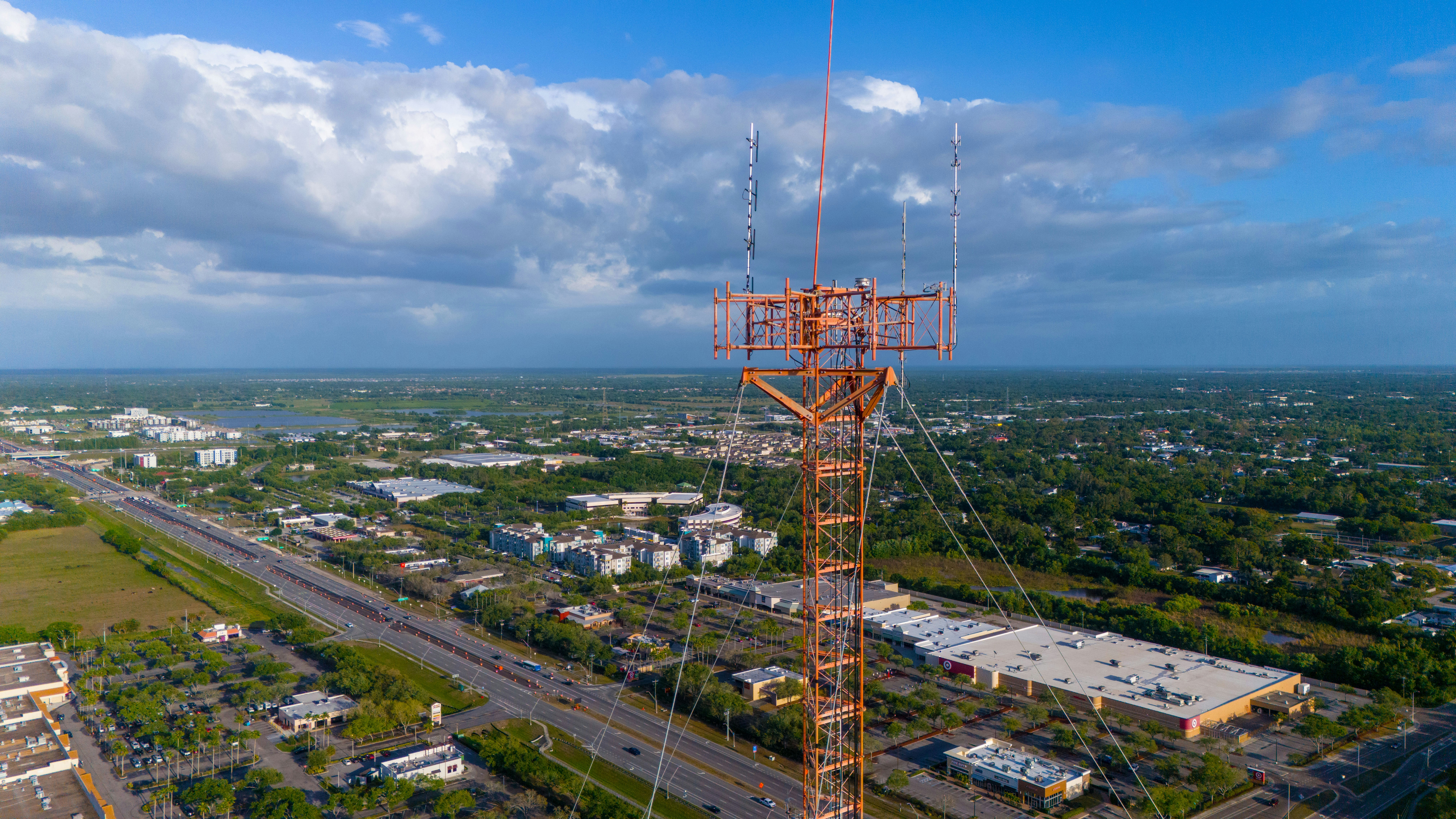 Tall radio tower overlooking a cityscape under cloudy sky