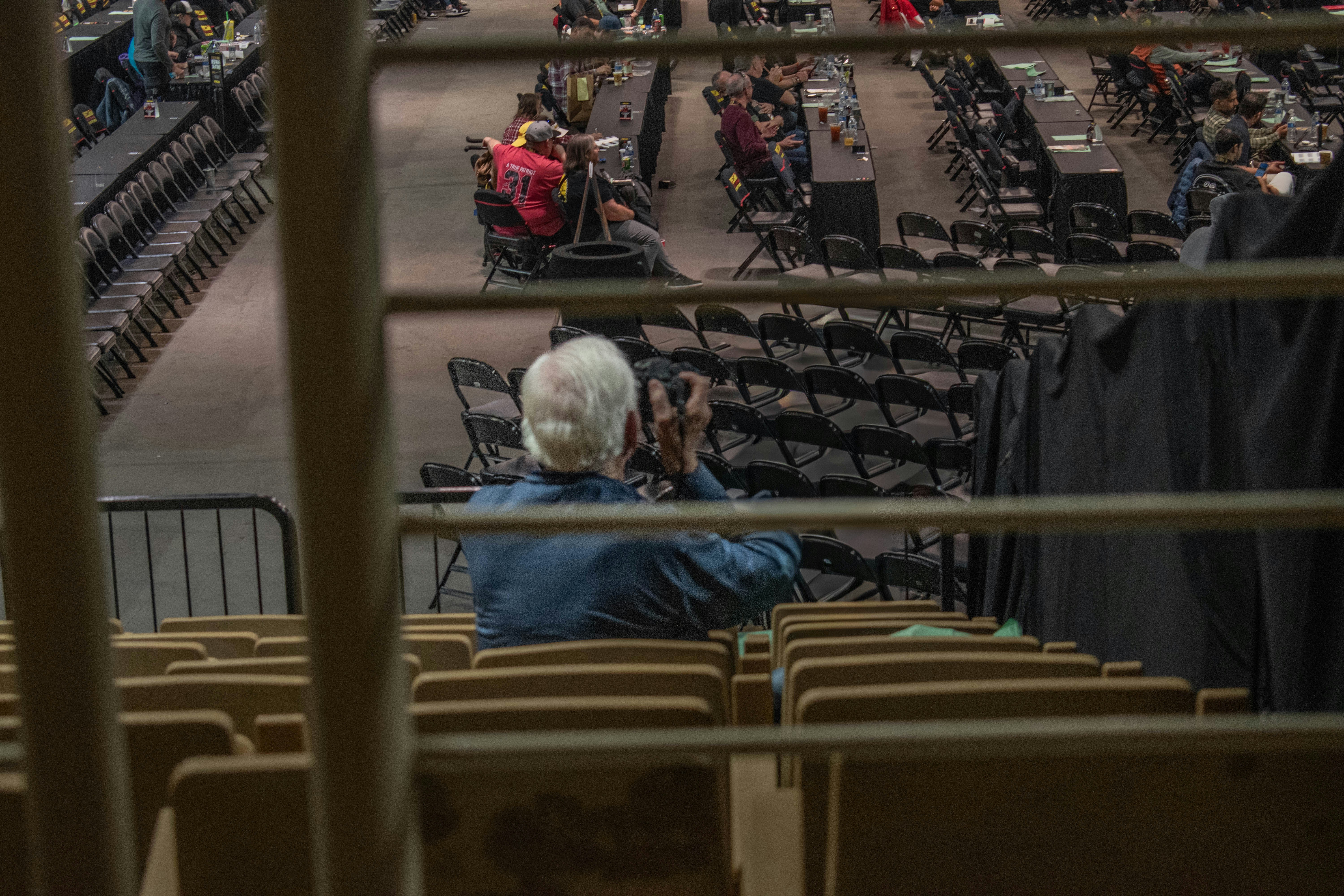 Elderly person in stadium seats looking at event below