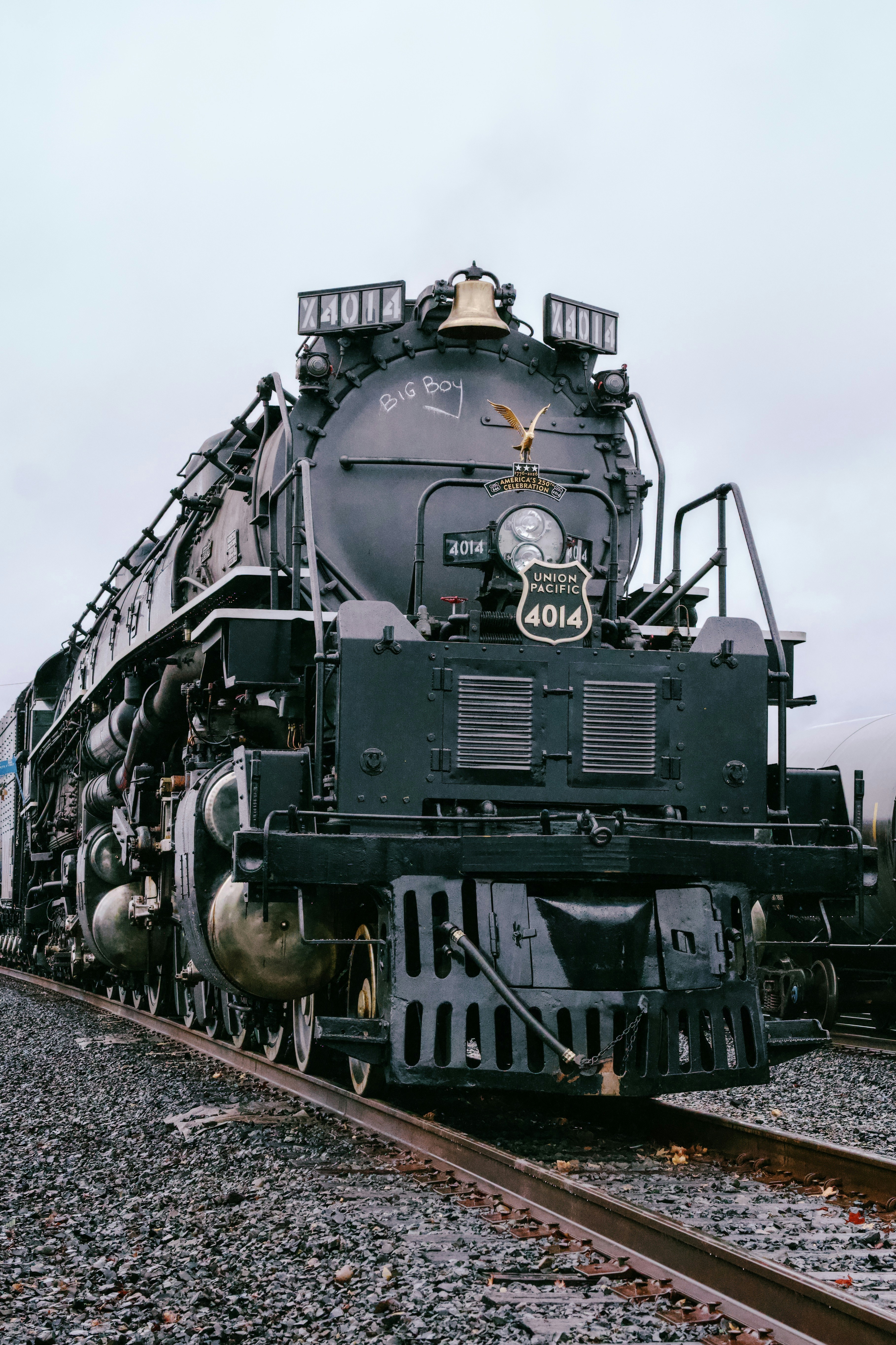 A large black steam locomotive sits on railroad tracks.