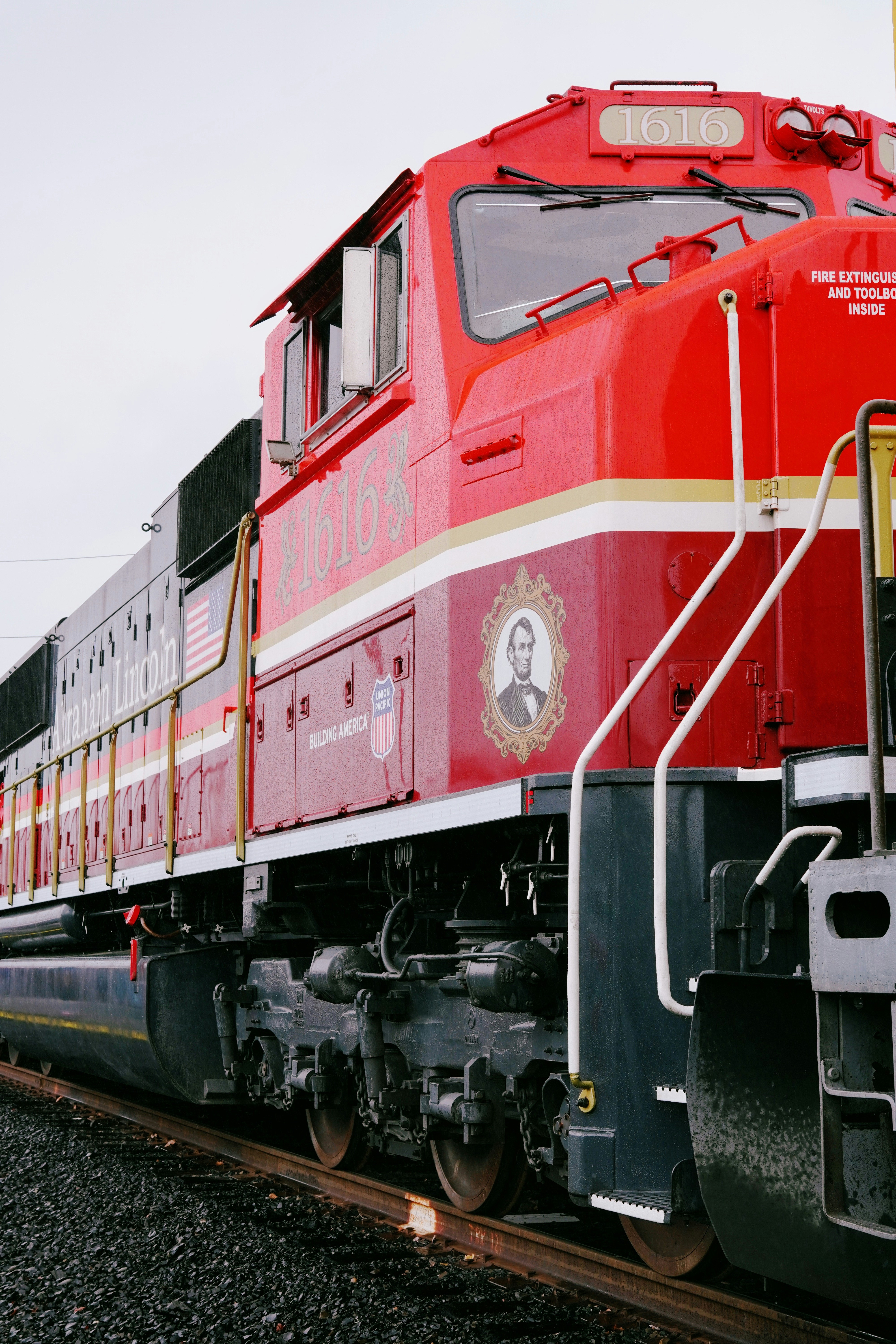A bright red locomotive with a portrait on its side.