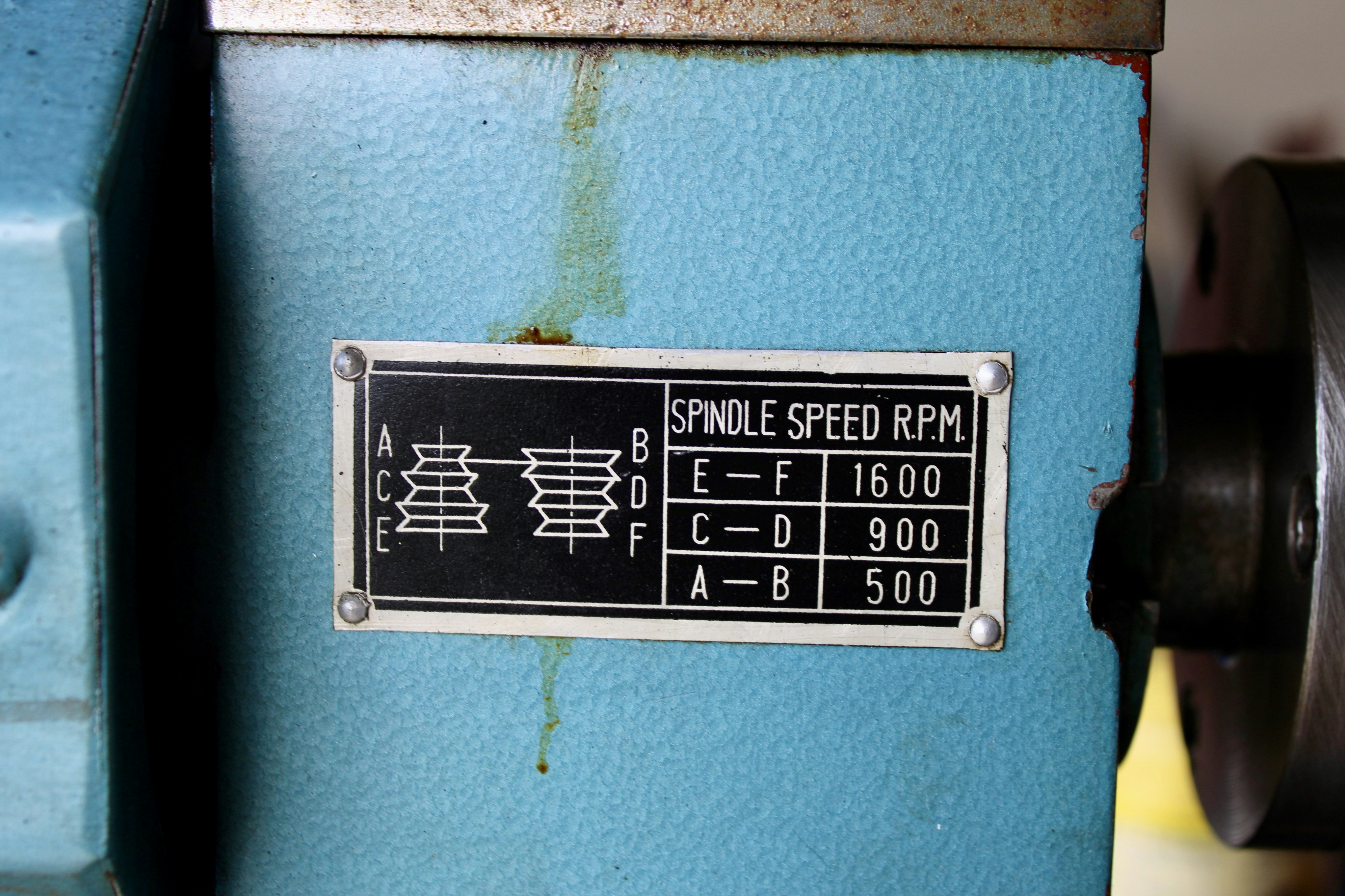 Close-up of a metal plate on a blue machine.