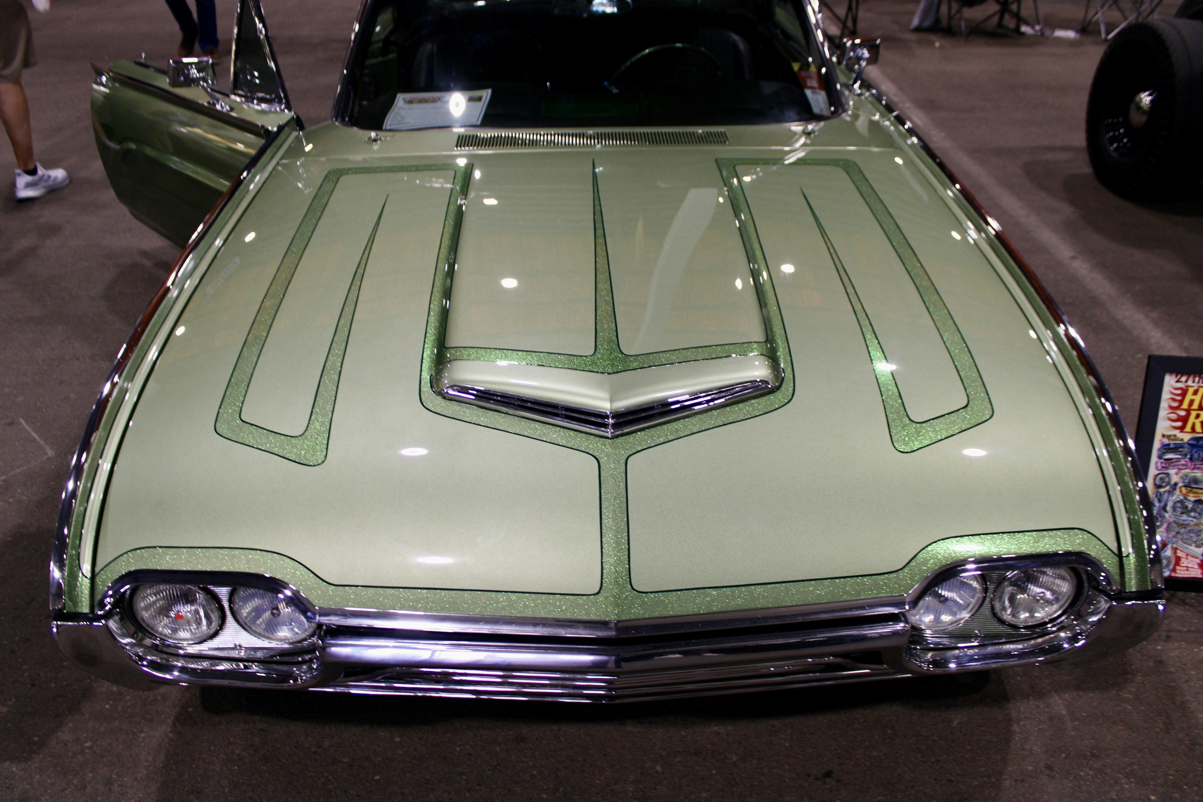A light green custom car with racing stripes.