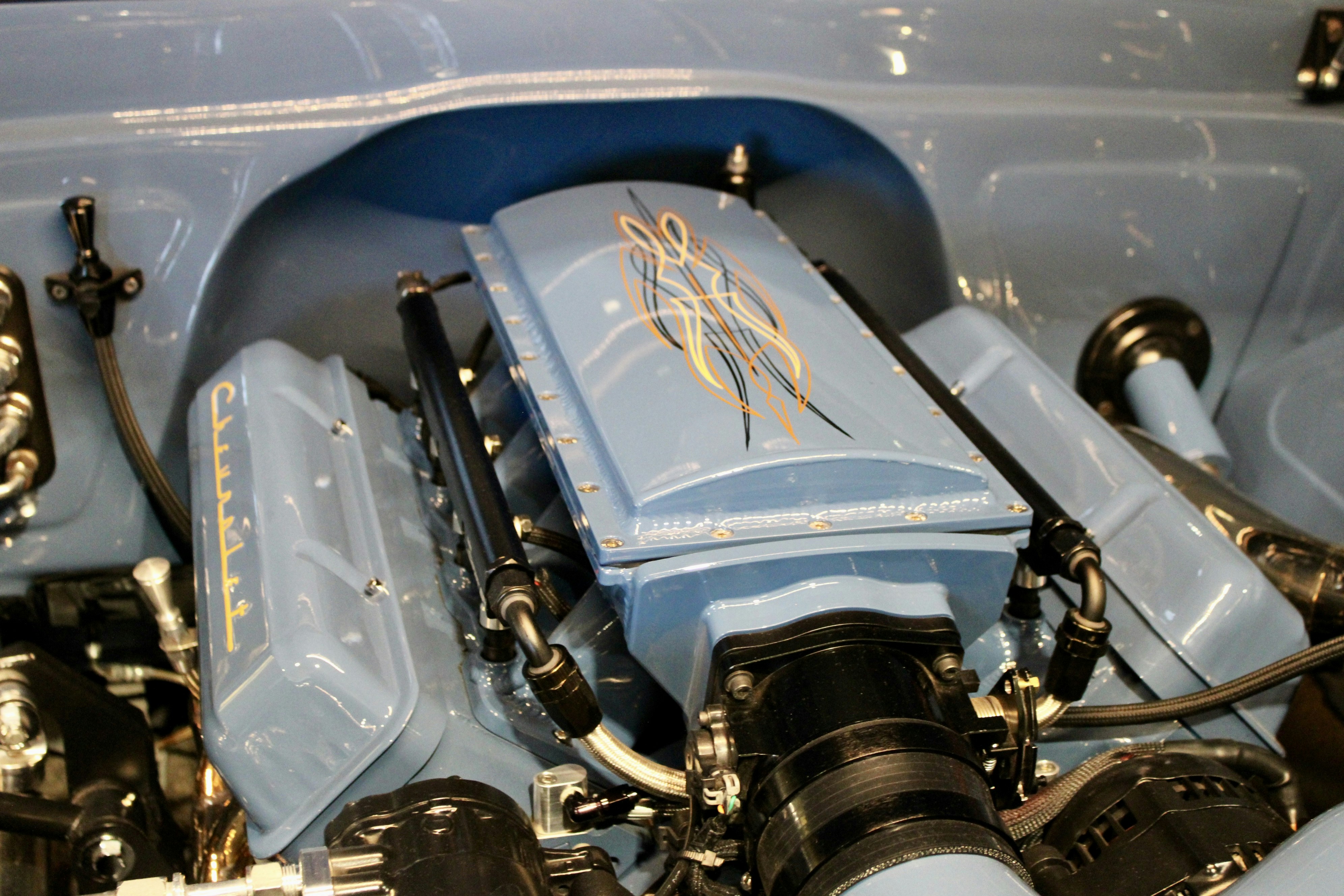 Close-up of a light blue car engine with custom details.