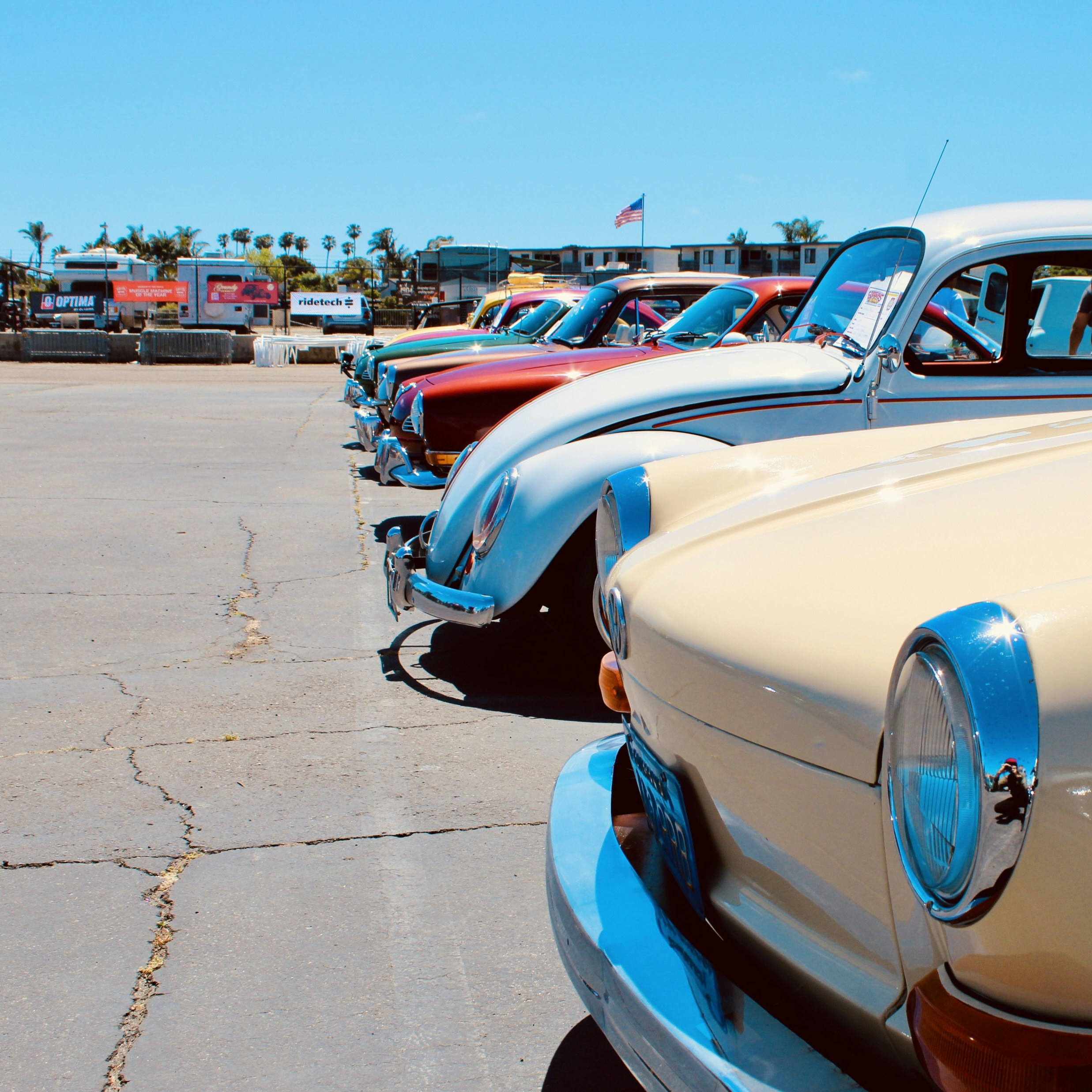 Row of vintage cars parked outside on a sunny day
