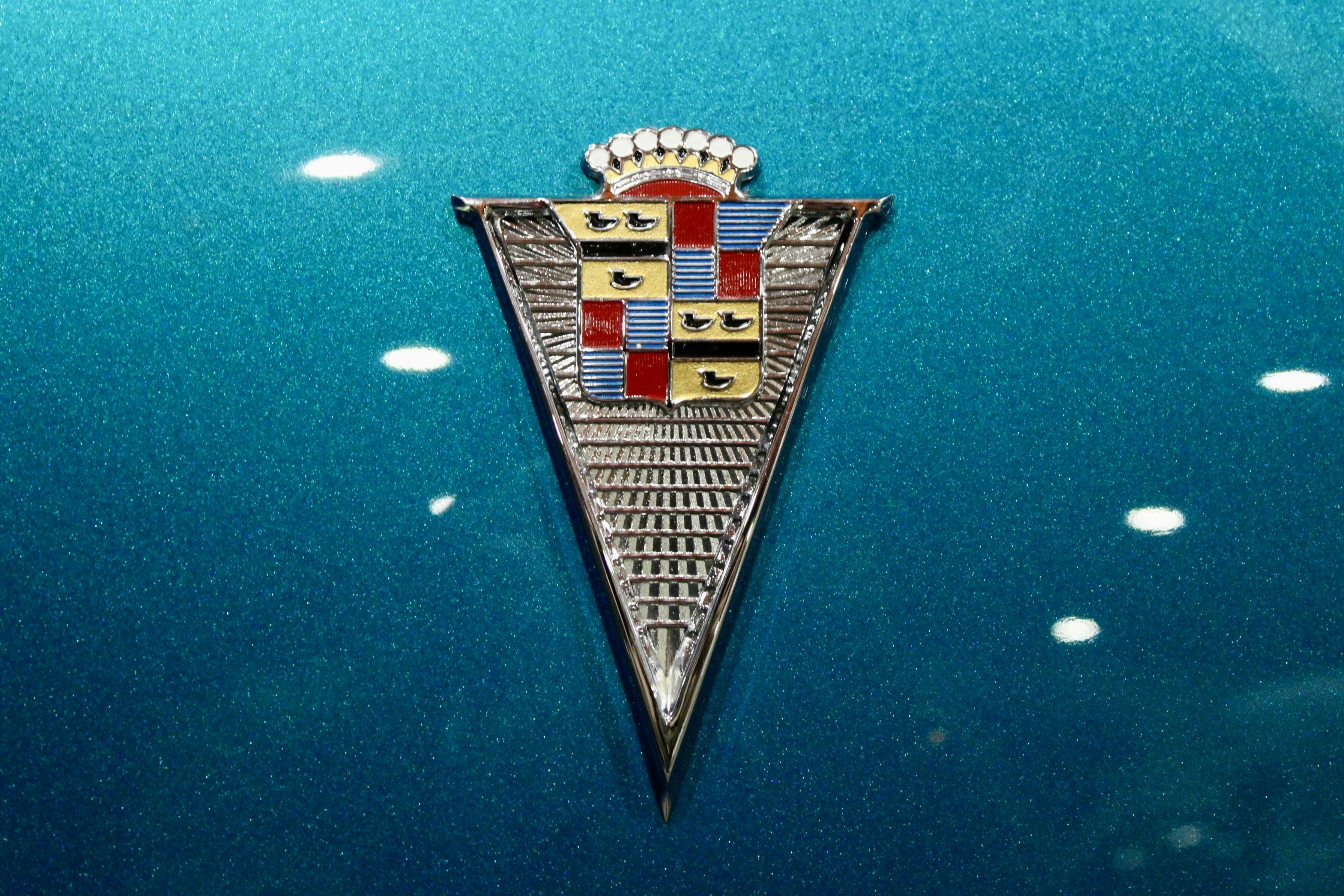 Close-up of a vintage car emblem on blue background