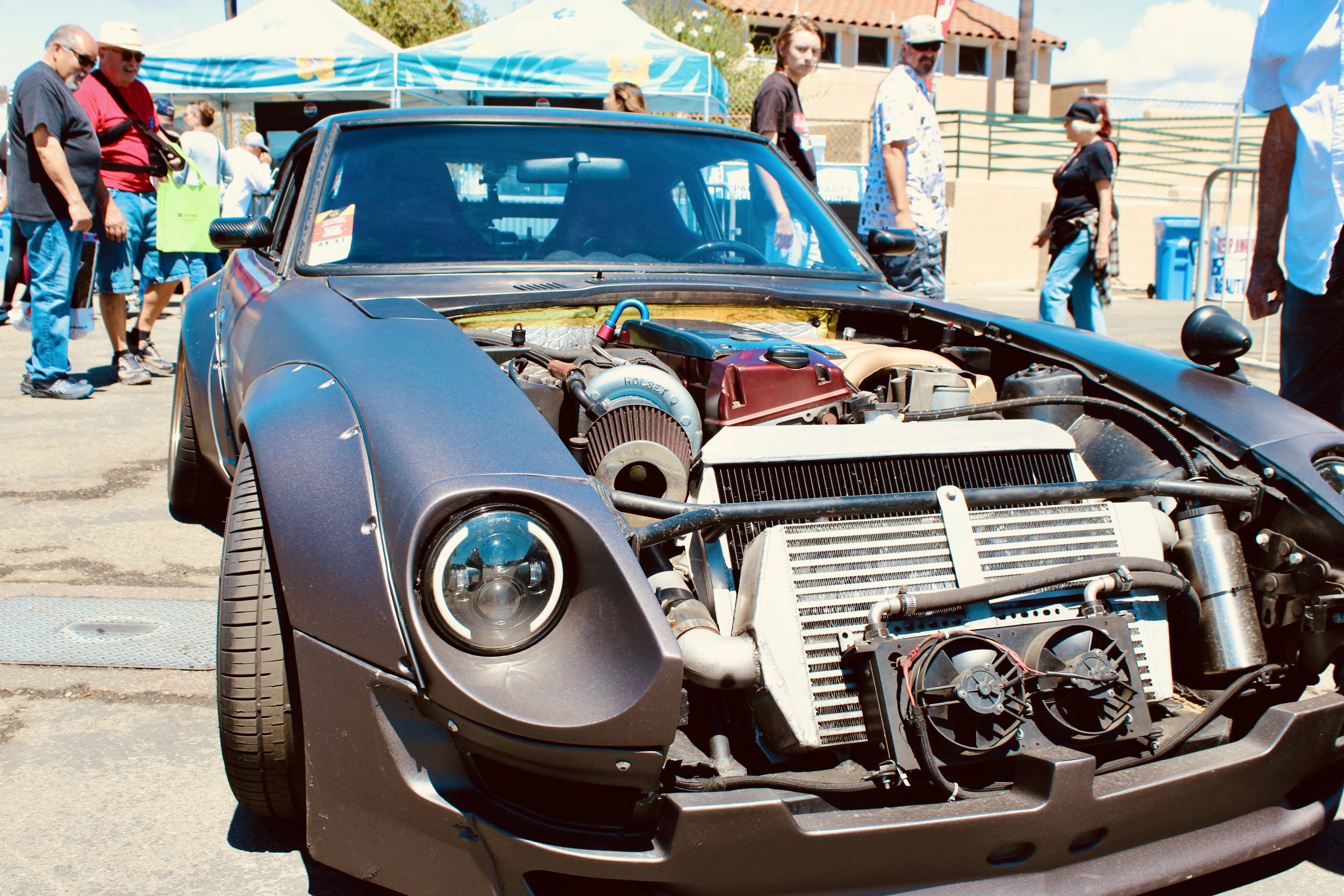 Customized car with engine exposed at an outdoor event