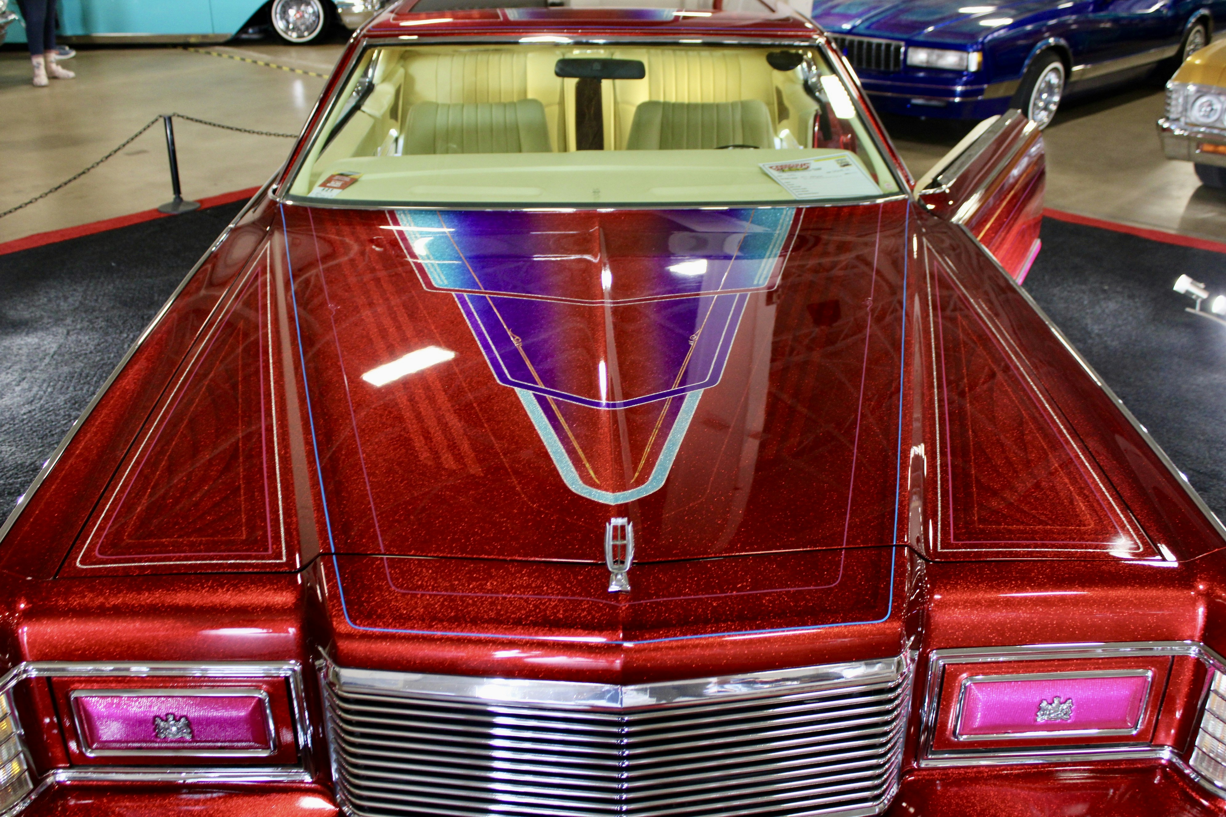 Custom red lowrider car with intricate paint design