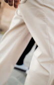 A person wearing light-colored pants and white sneakers.