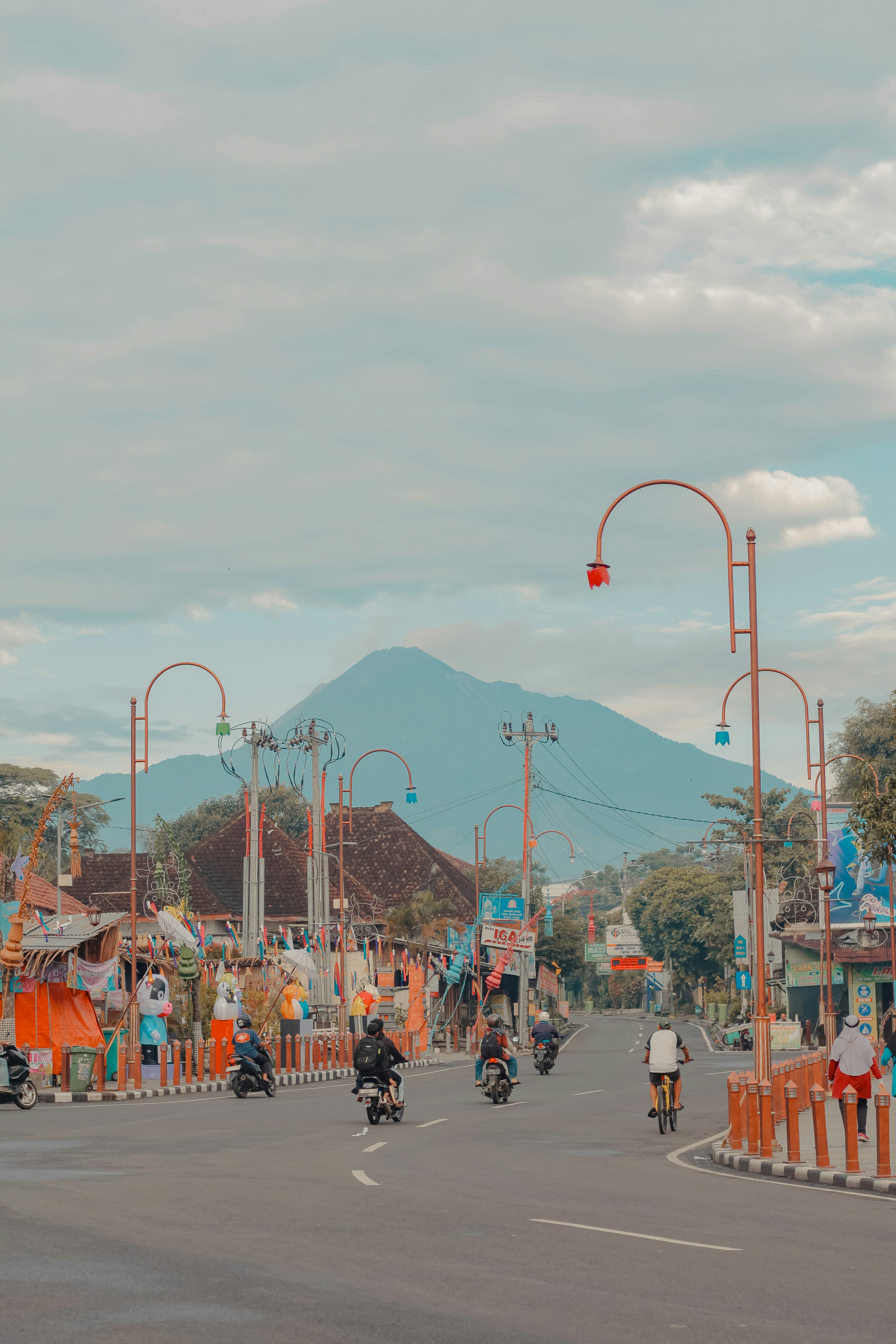 Pemandangan jalanan dengan sepeda motor dan latar belakang gunung.