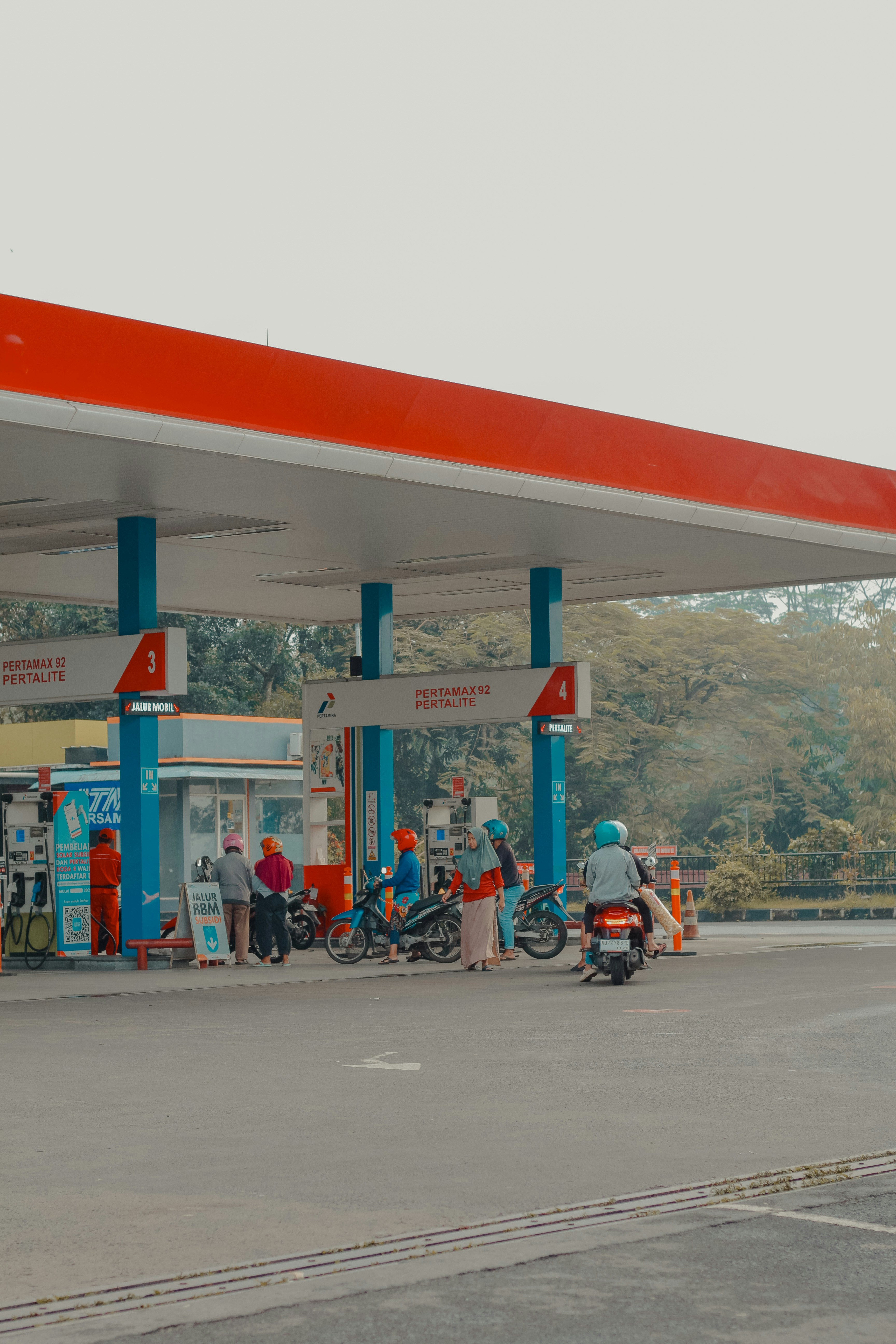 Orang-orang di pompa bensin dengan sepeda motor