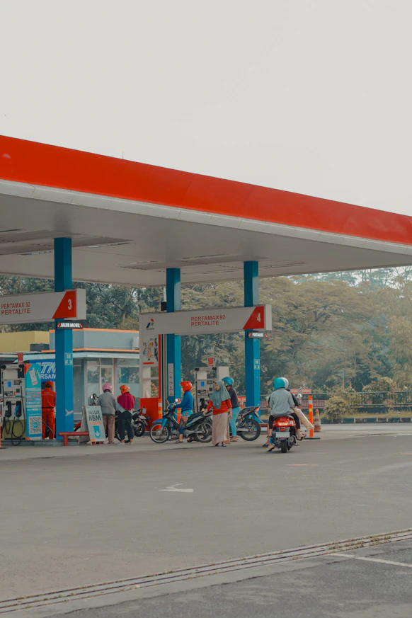 People at a gas station with motorcycles