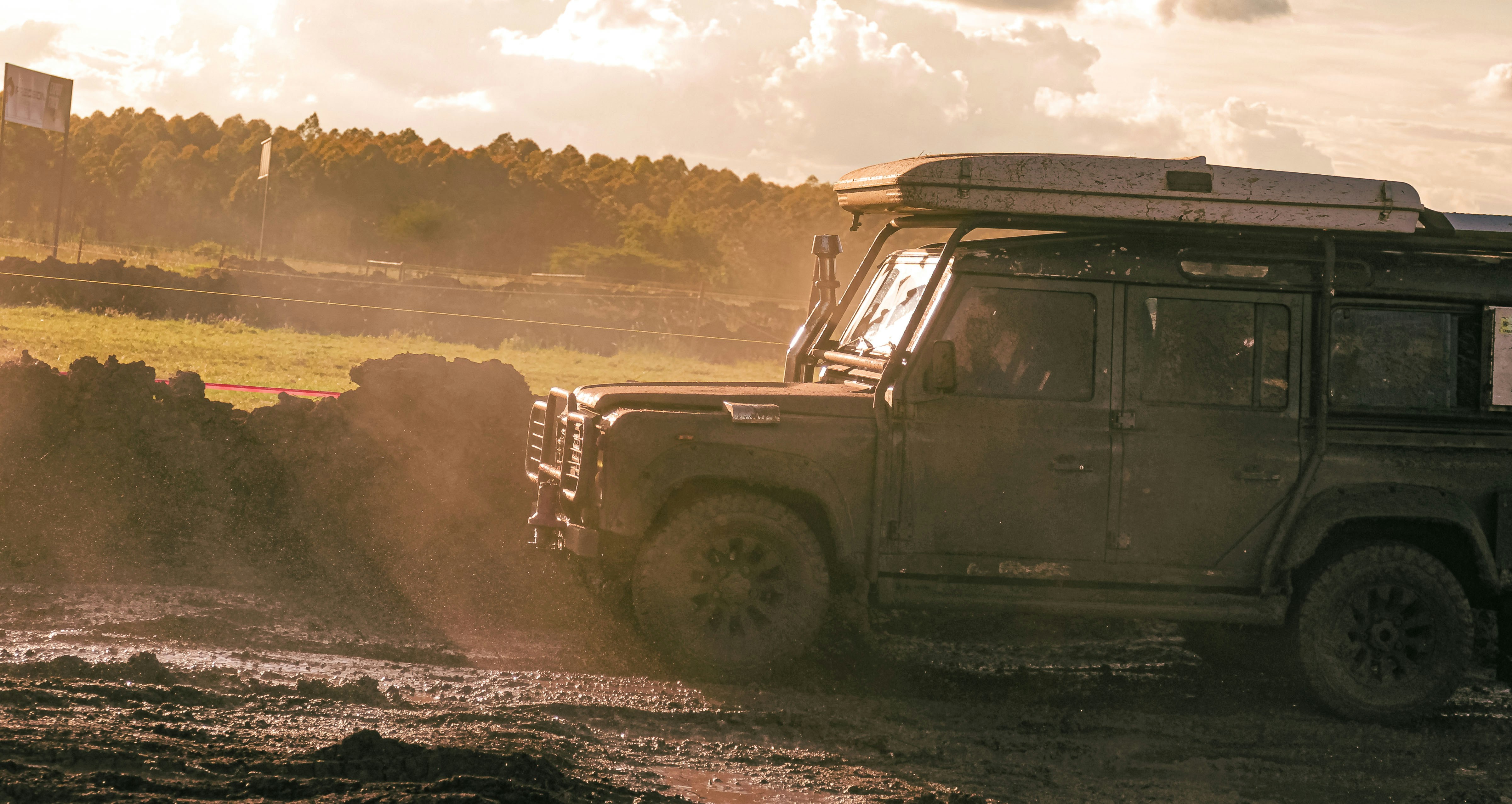 A rugged off-road vehicle driving through muddy terrain.