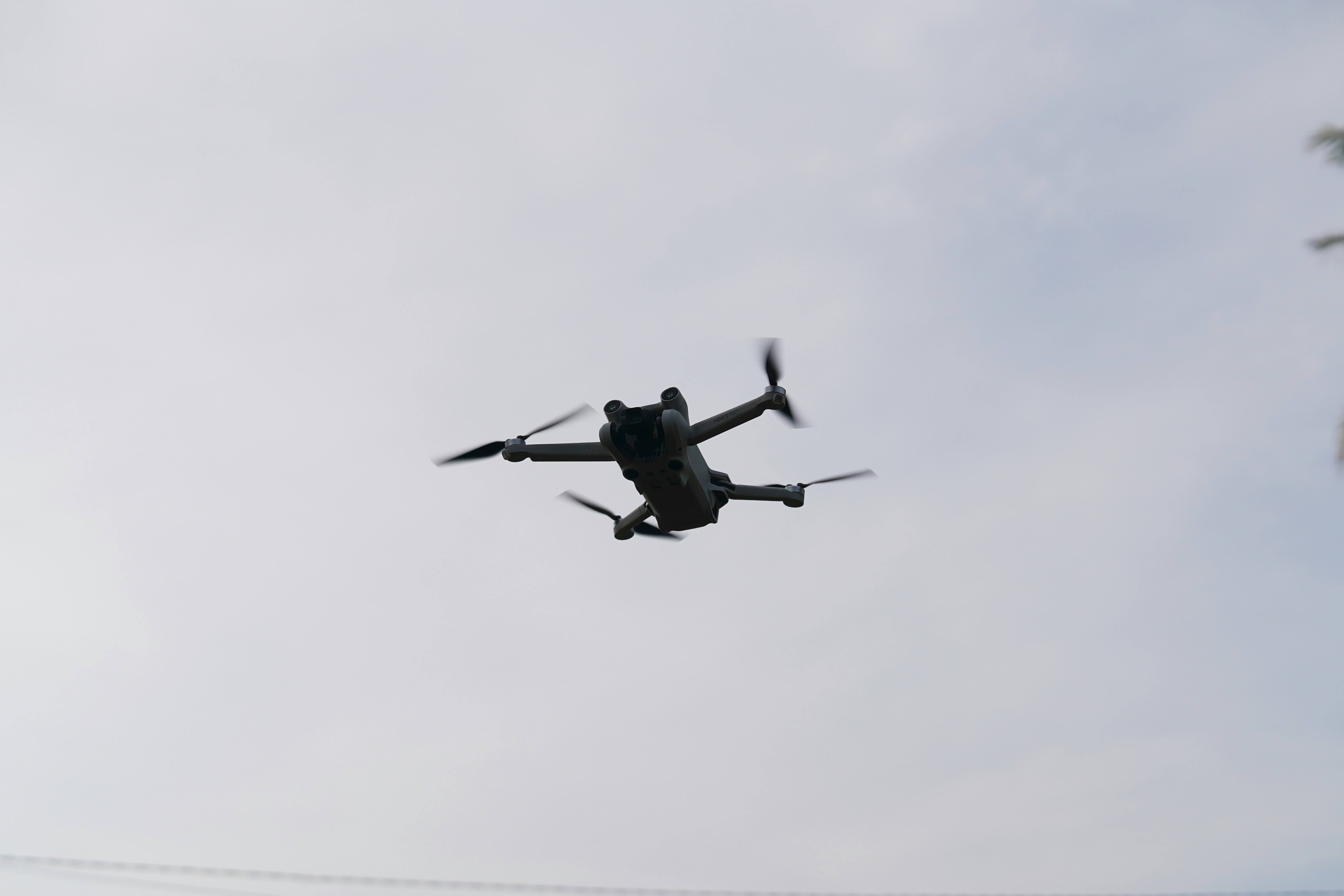 A drone flies in the cloudy sky