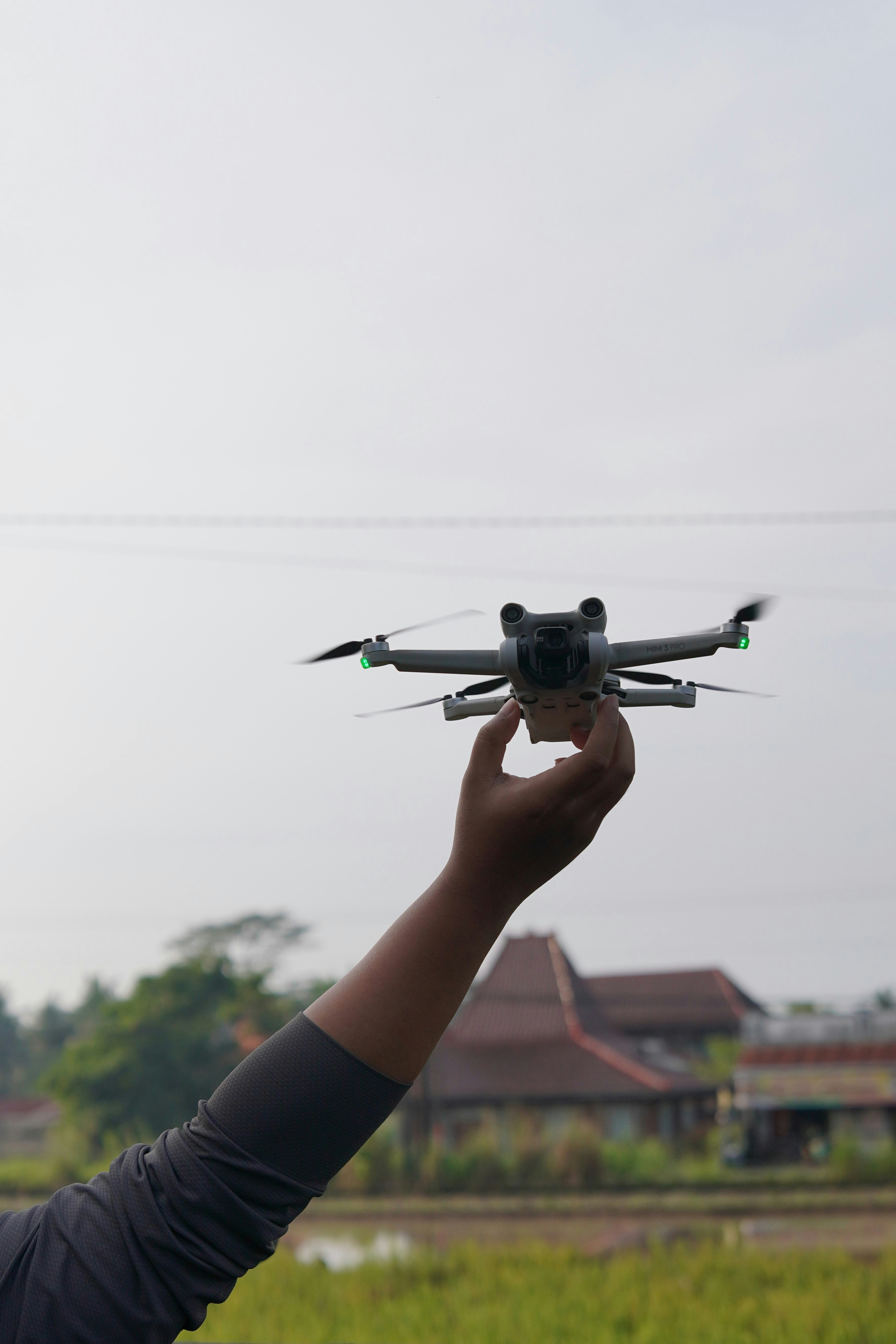 Hand holding a drone with a blurry background