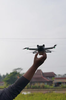 Hand holding a drone with a blurry background