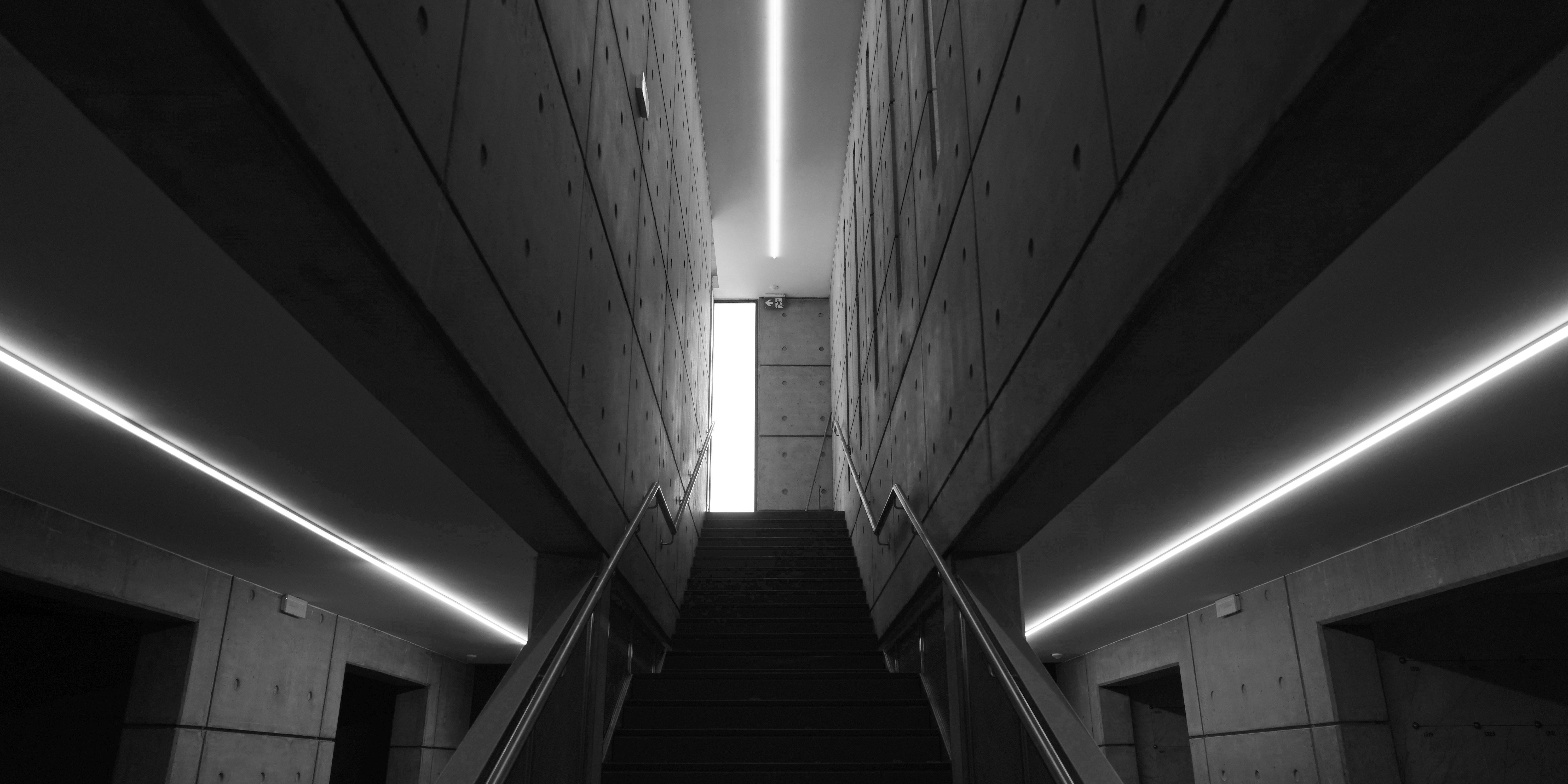 Modern staircase with linear lighting and concrete walls