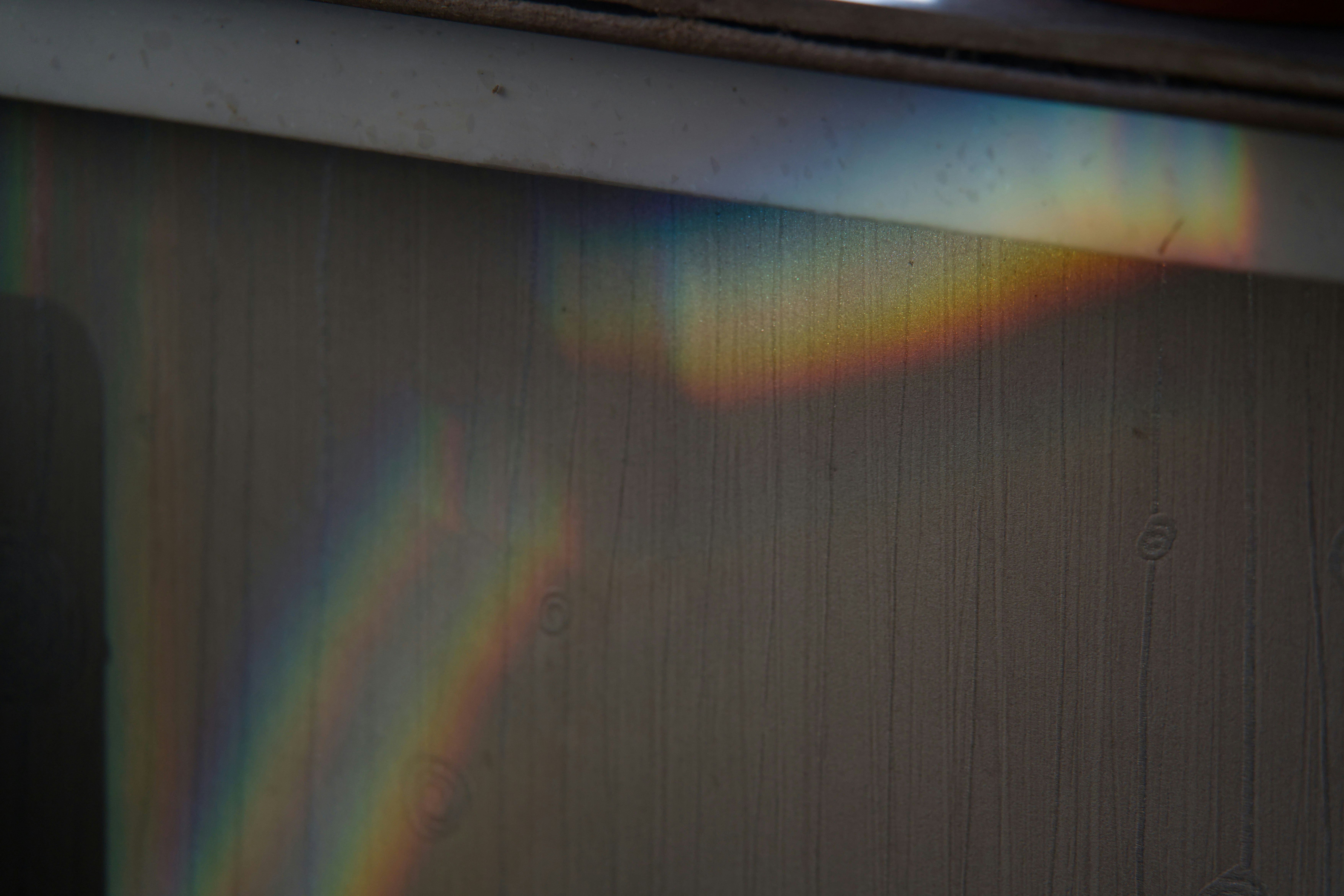 Luz arcoíris refractada en una pared texturizada.