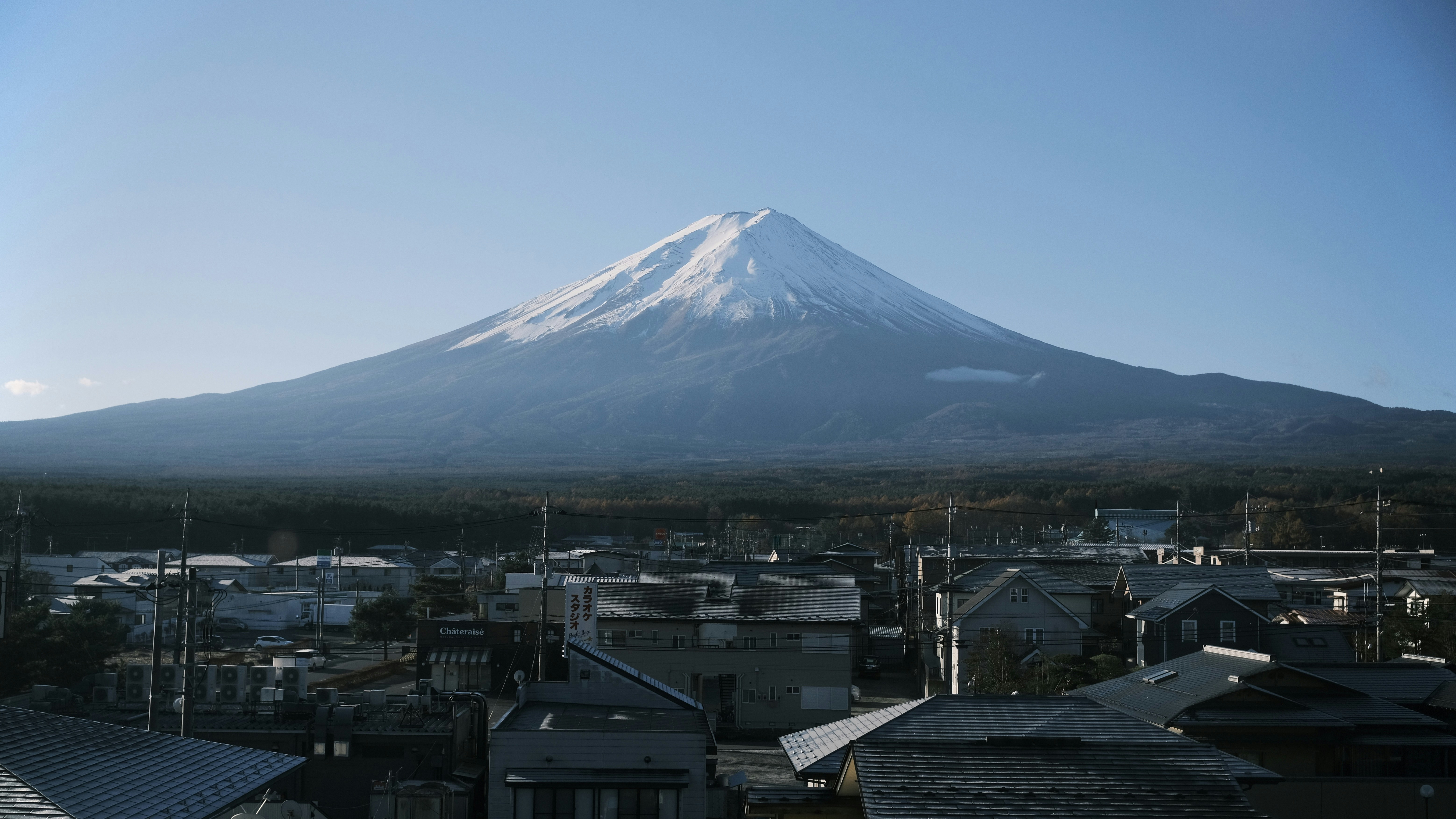 Snow-capped mount fuji looms over a small town.