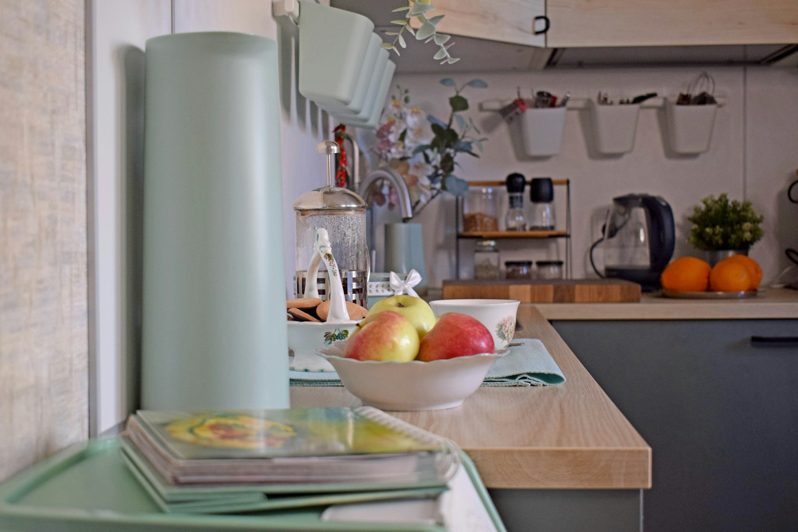 light blue apartment kitchen counter with fruit and magazines
