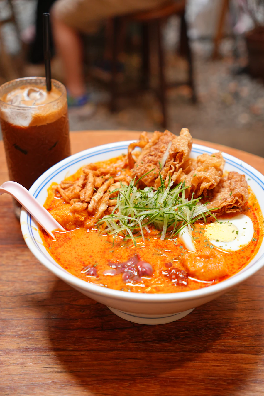A bowl of creamy laksa with fried toppings