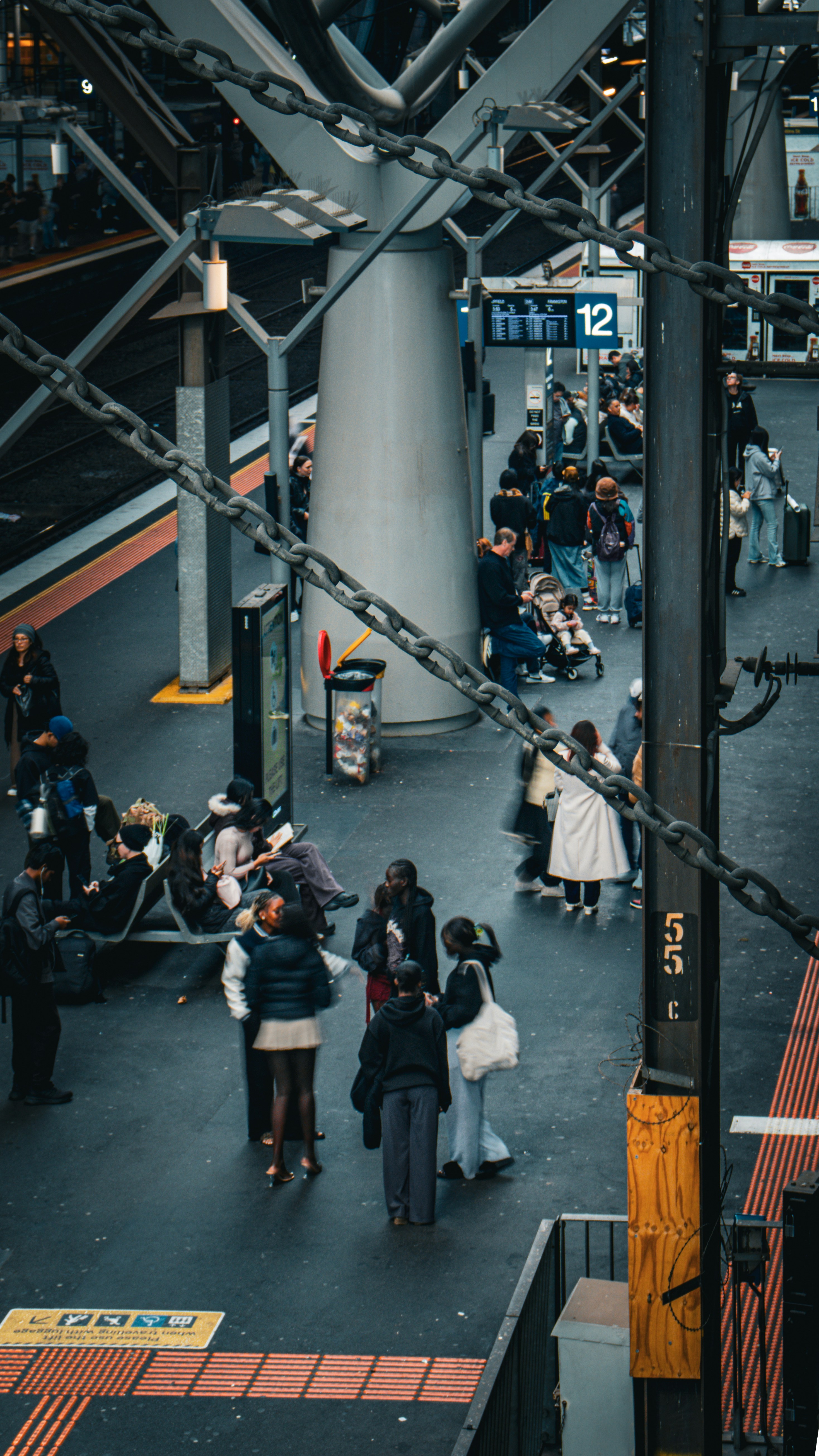 Gente esperando en un andén concurrido de la estación de tren.