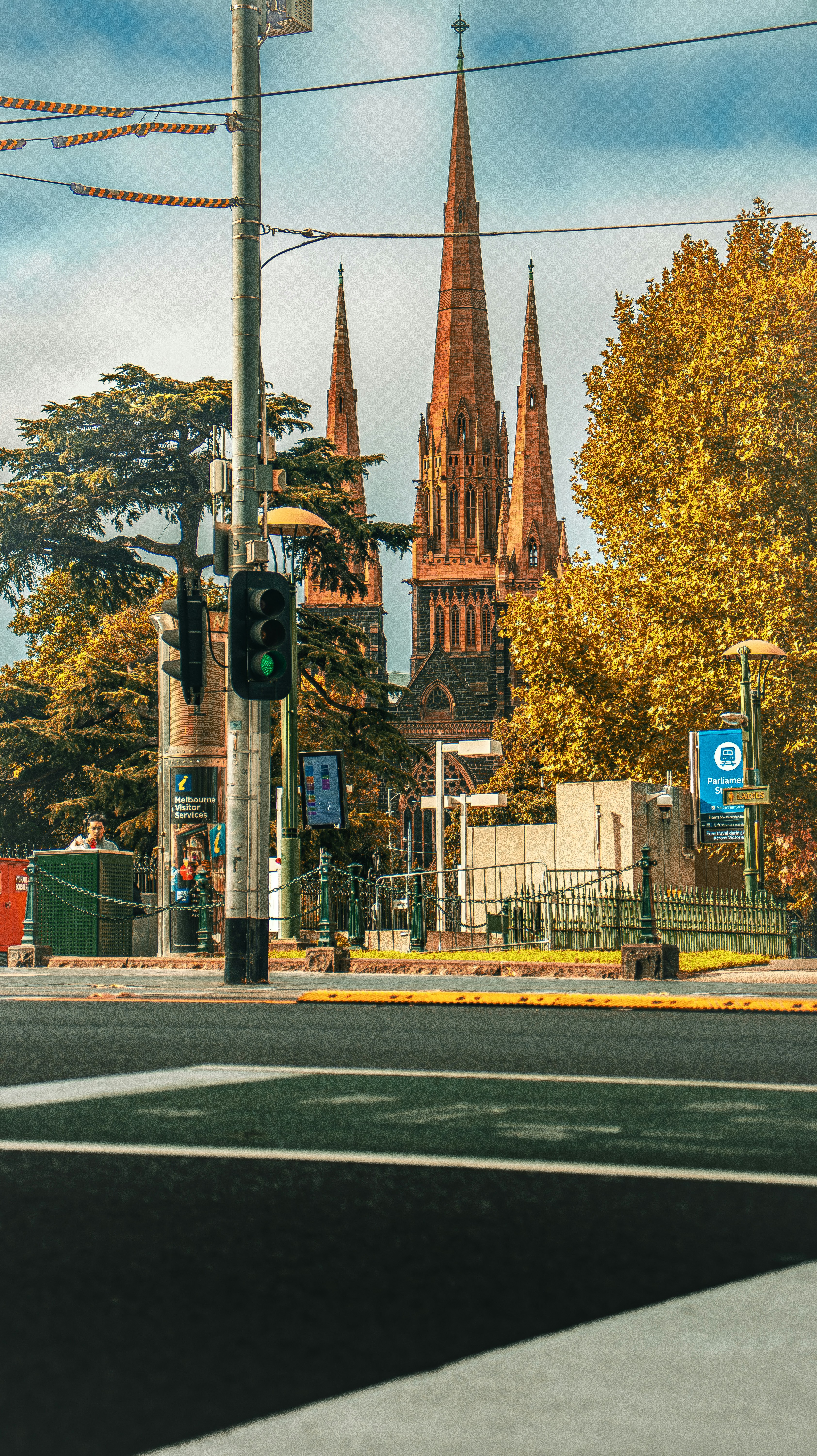 Una iglesia con altas agujas detrás de árboles otoñales