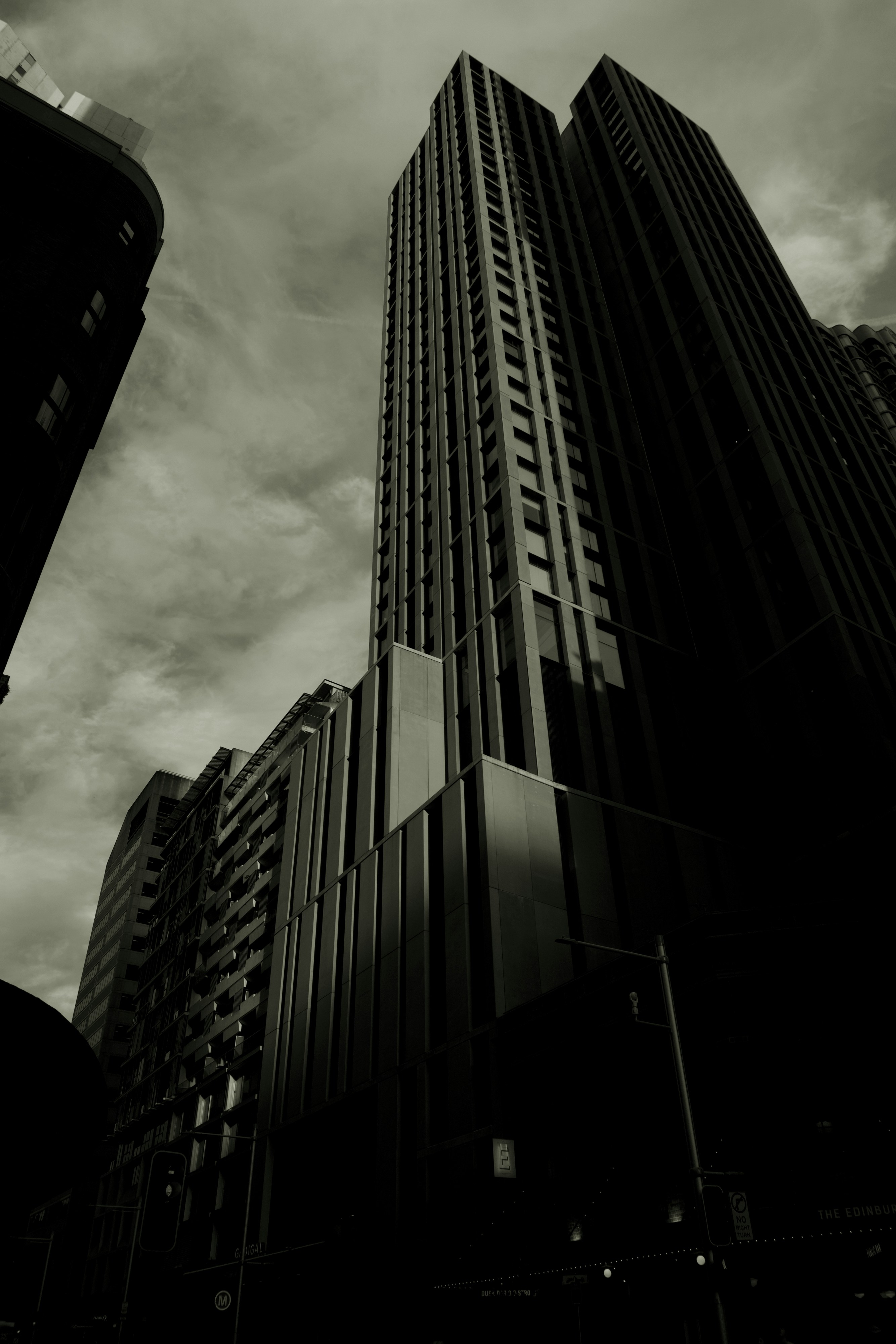 Low angle view of modern skyscrapers against cloudy sky.