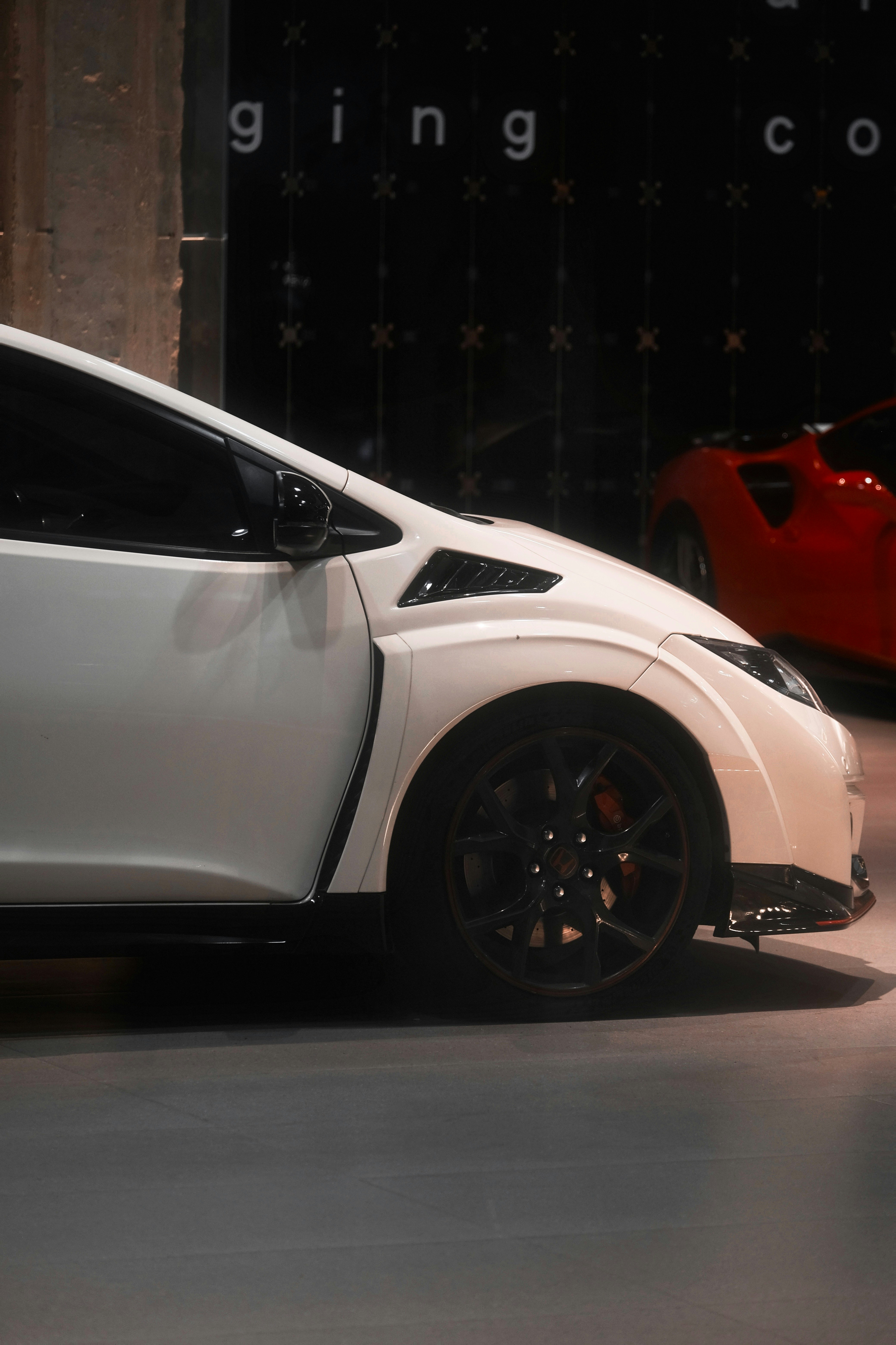 White sports car with black wheels and red brake calipers
