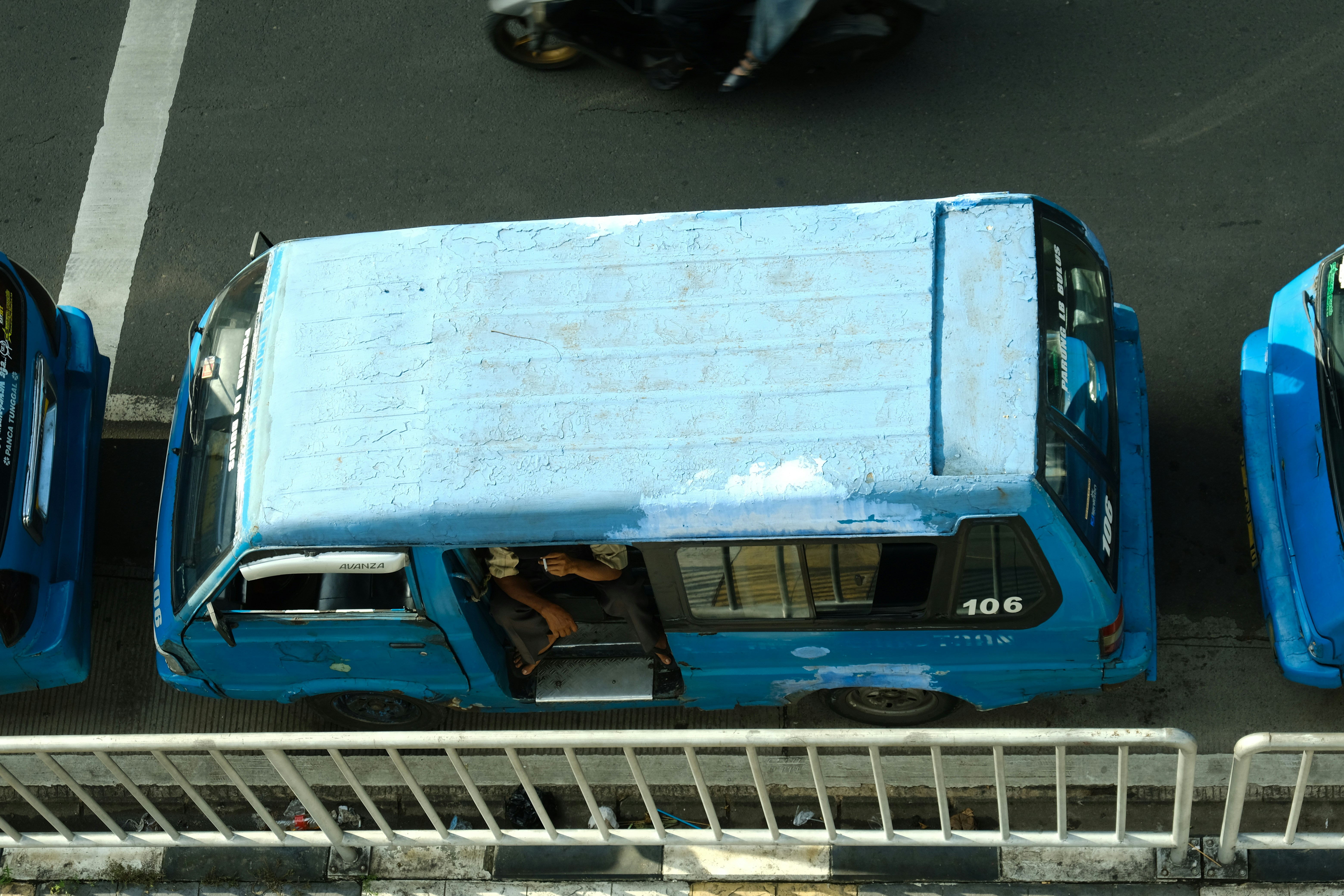 A blue van parked on a street (Photo by Palina Kharlanovich on Unsplash)