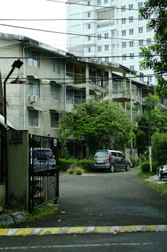 Apartment buildings with parked cars on a street.