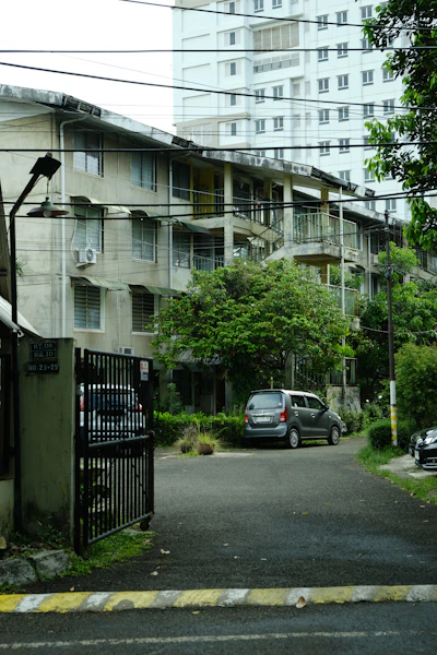 Apartment buildings with parked cars on a street.