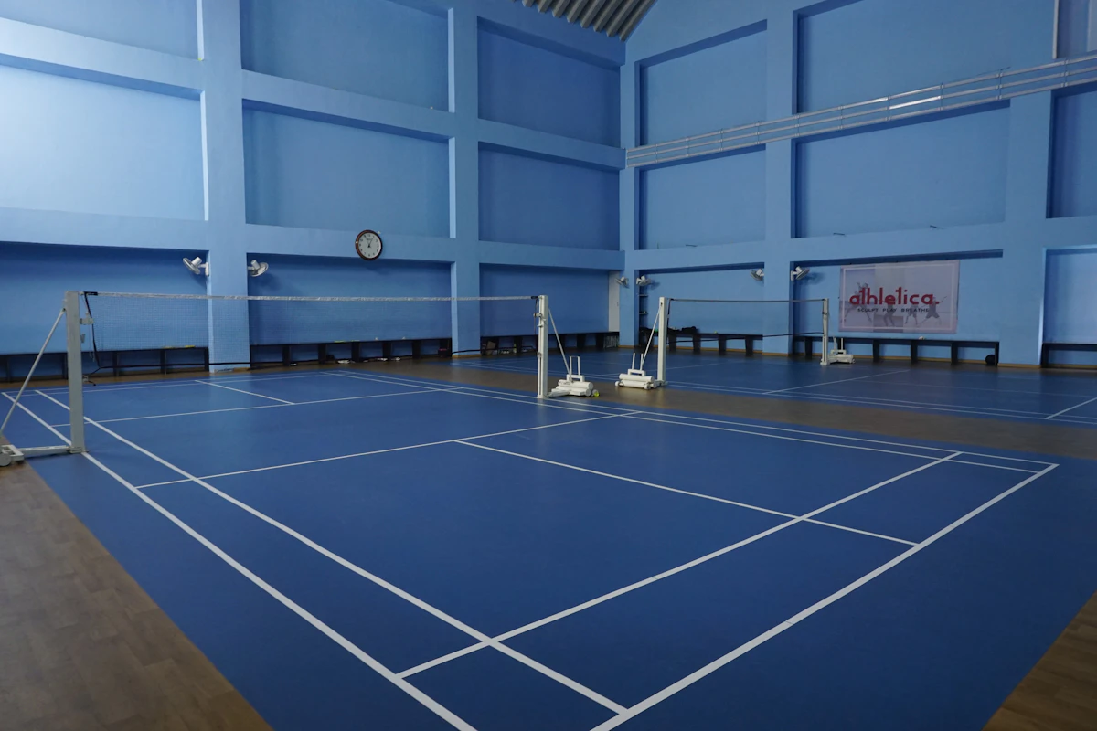 Empty indoor sports court with blue flooring, overhead view, no players present