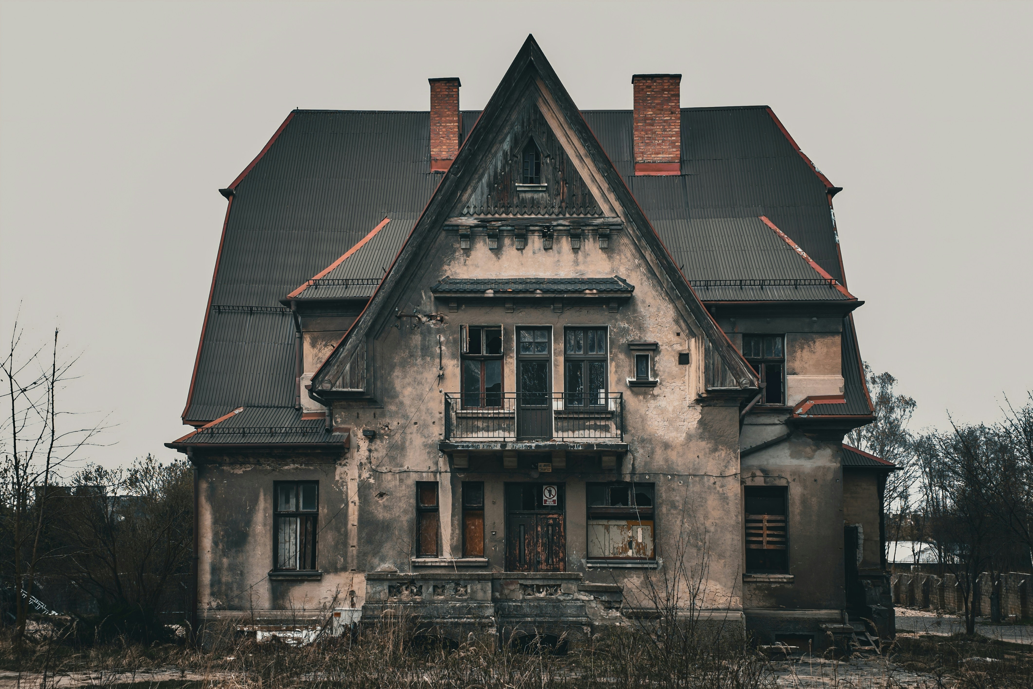 An old, dilapidated house under a cloudy sky.