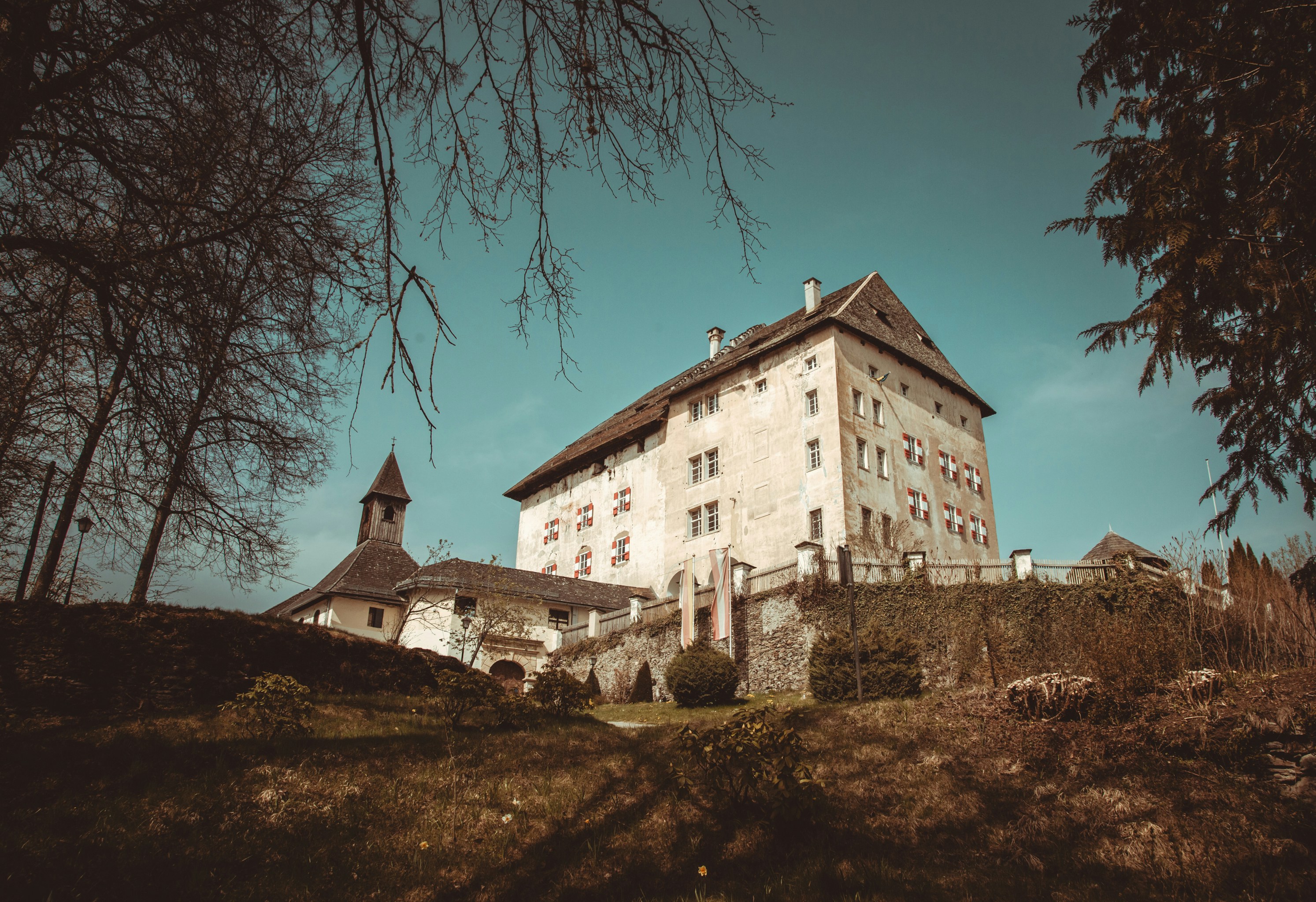 Ein historisches Schloss mit einer Kirche auf einem Hügel.