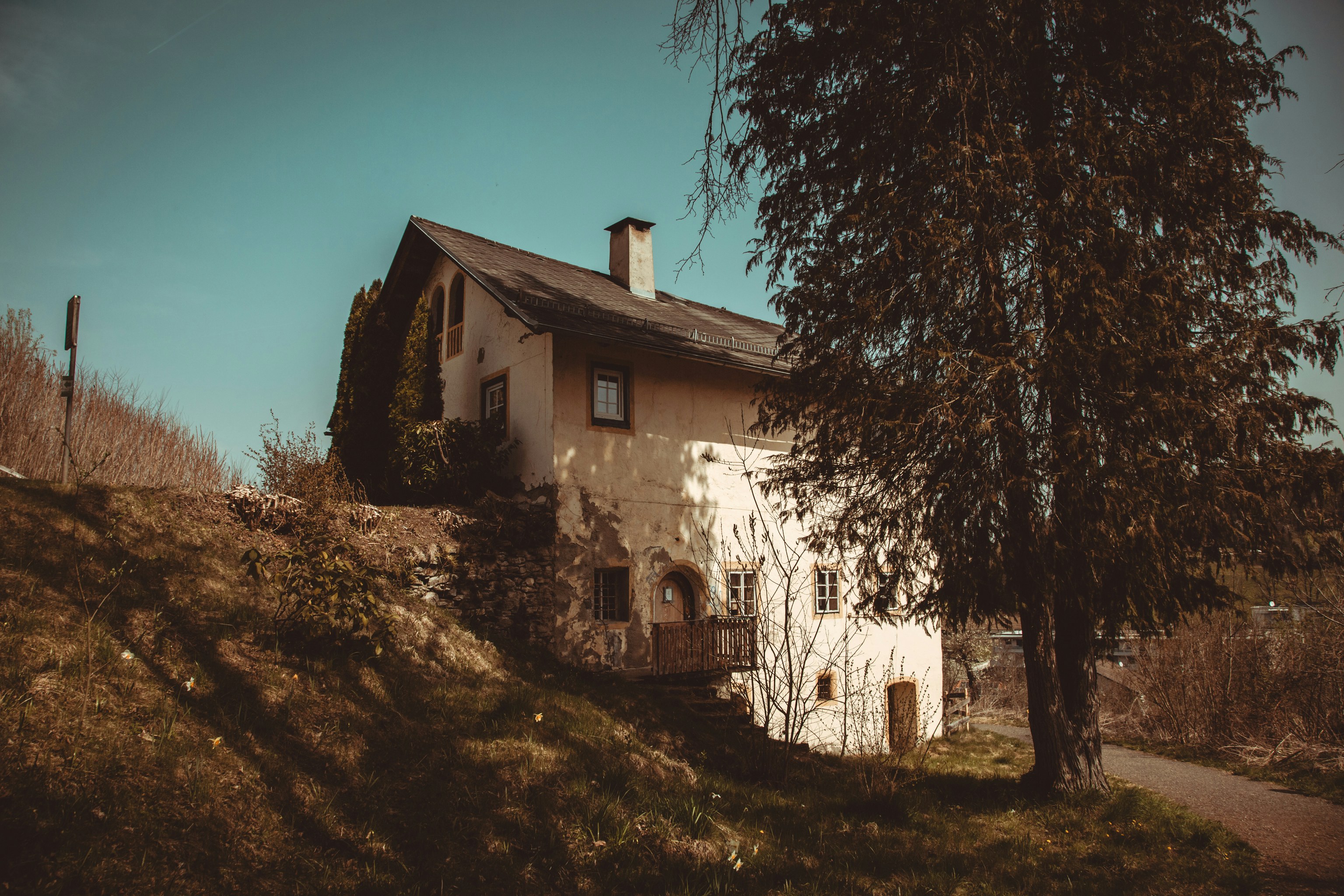 Ein rustikales Haus, eingebettet an einem grasbewachsenen Hang.